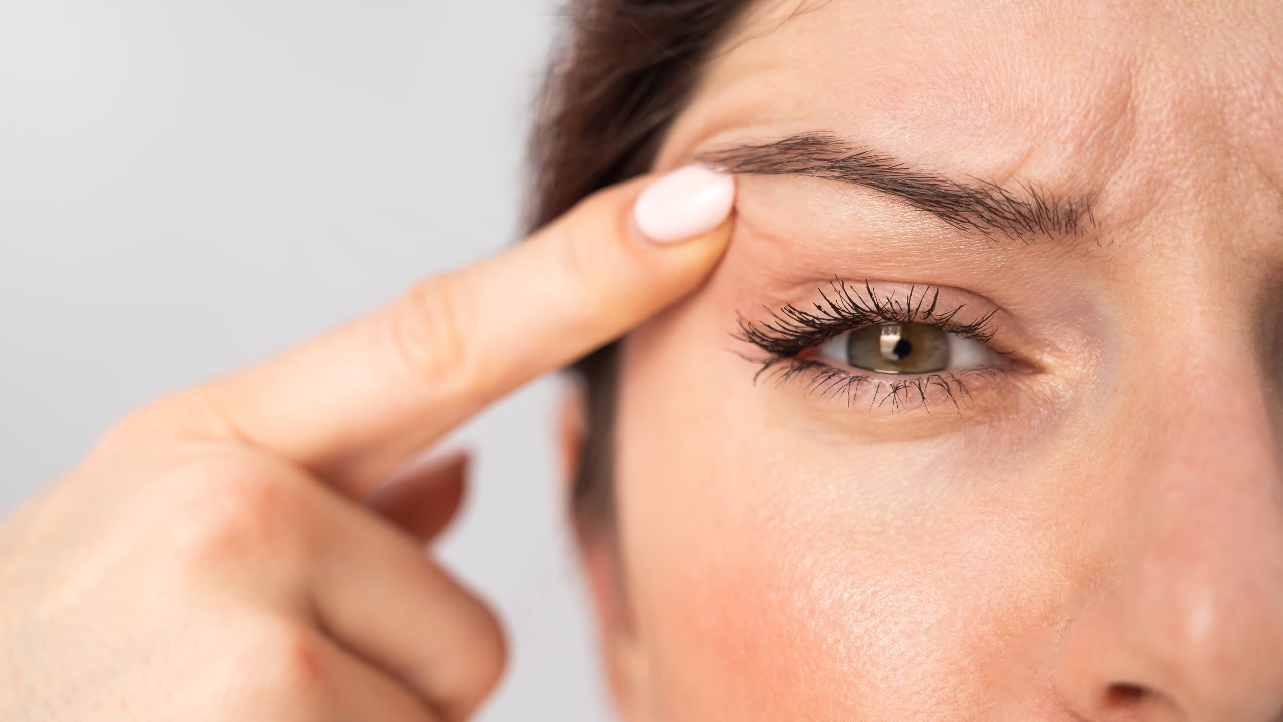 Una mujer con temblores en el párpado (AdobeStock)