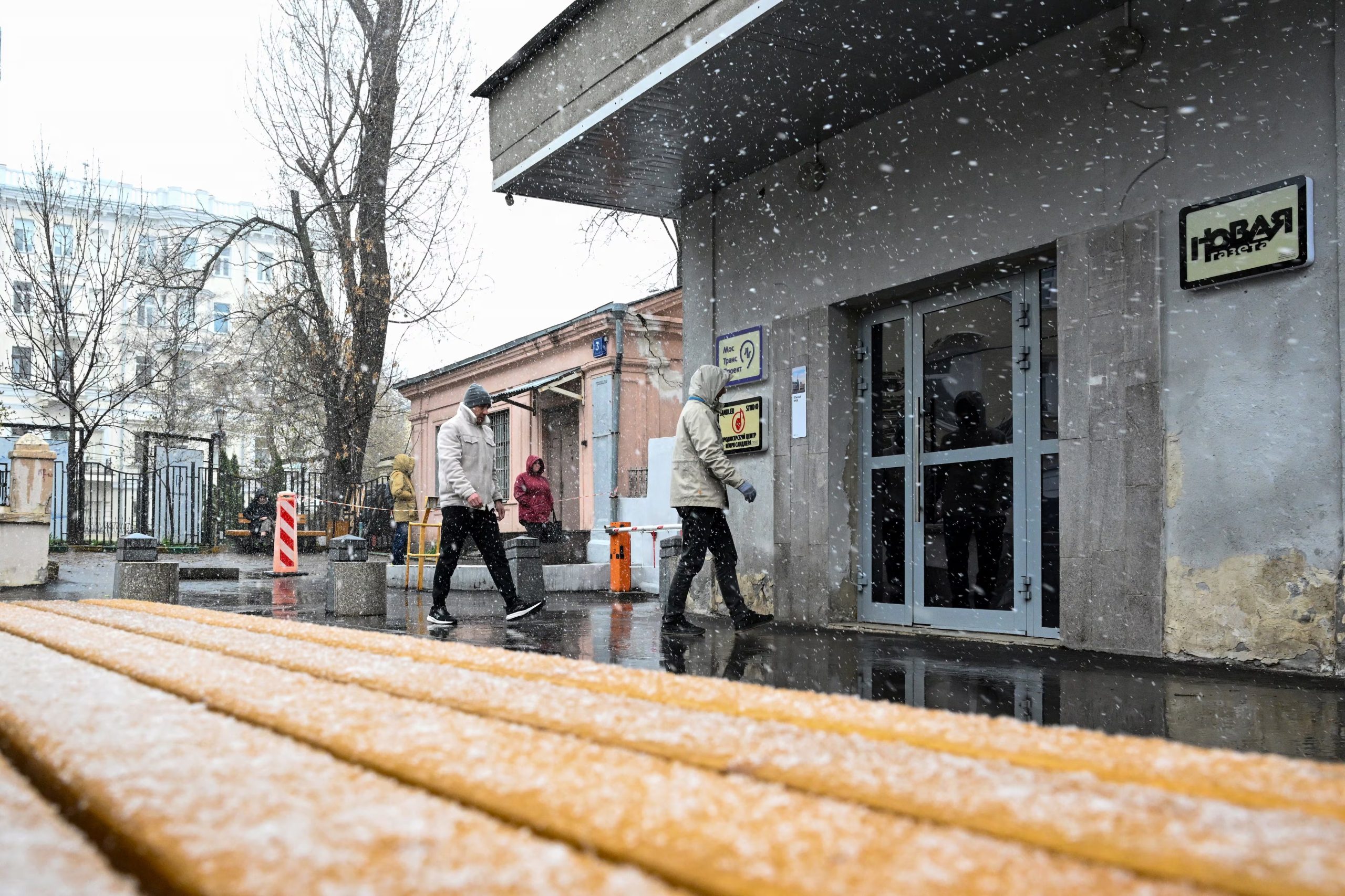 Hombres caminan frente a la redacción de Nóvaya Gazeta en Moscú este jueves durante el operativo policial. El Ministerio del Interior invocó un caso de uso ilegal de datos personales para justificar el registro. (Igor Ivanko/AFP)