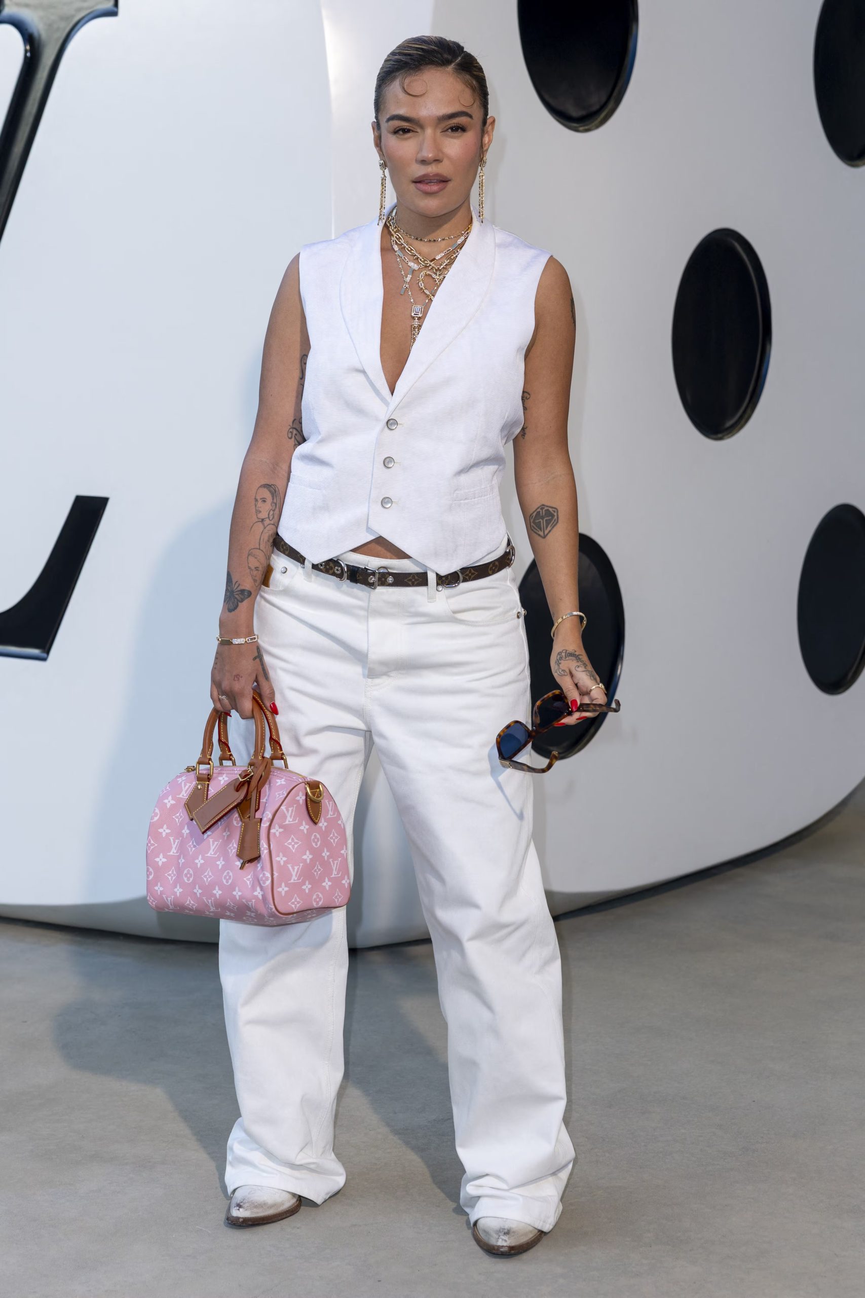 La combinación de mezclilla blanca y accesorios dorados da como resultado un aire sofisticado y moderno en el look relajado de Karol G (Best Image/The Grosby Group)