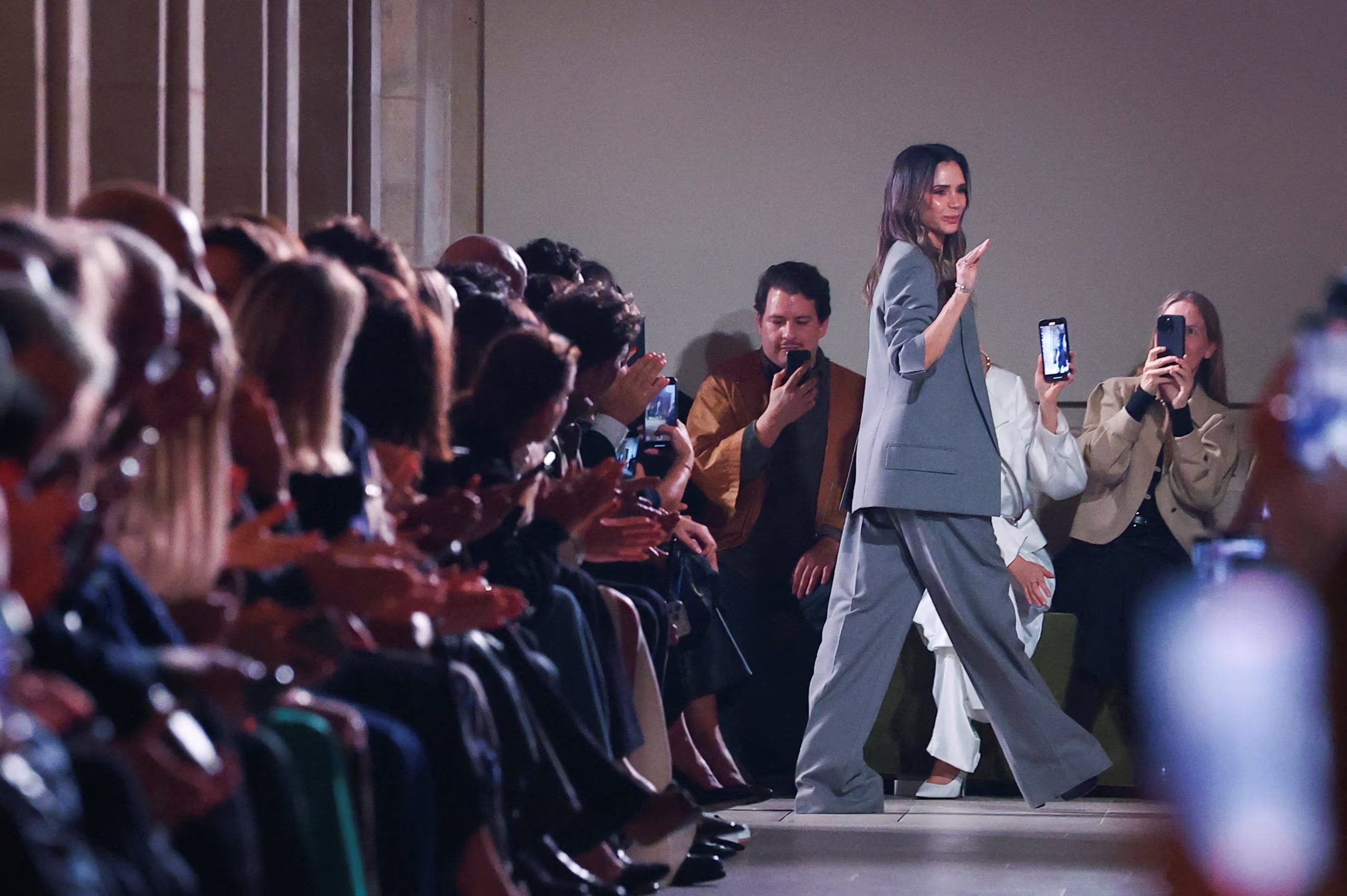 El pantalón de traje gris claro y talle alto, junto al tejido ligero, enfatiza la tendencia hacia una sastrería relajada en el estilo de Victoria Beckham (REUTERS/Gonzalo Fuentes)