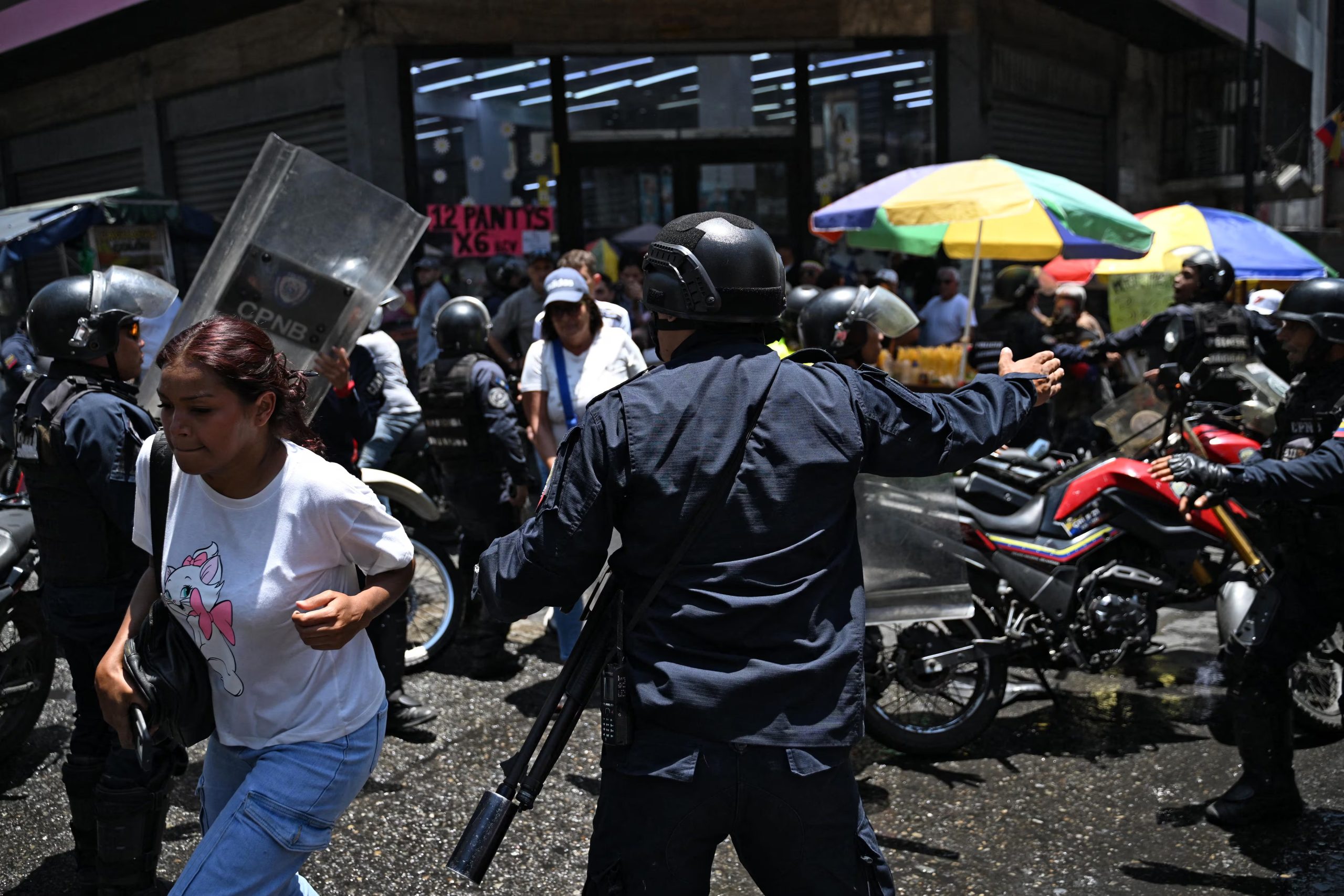 Agentes de policía reprimen a manifestantes en Caracas (AFP)