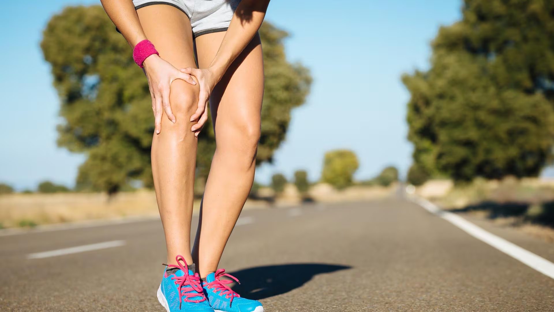 Una chica se duele de la rodilla mientras hace ejercicio. (iStock)