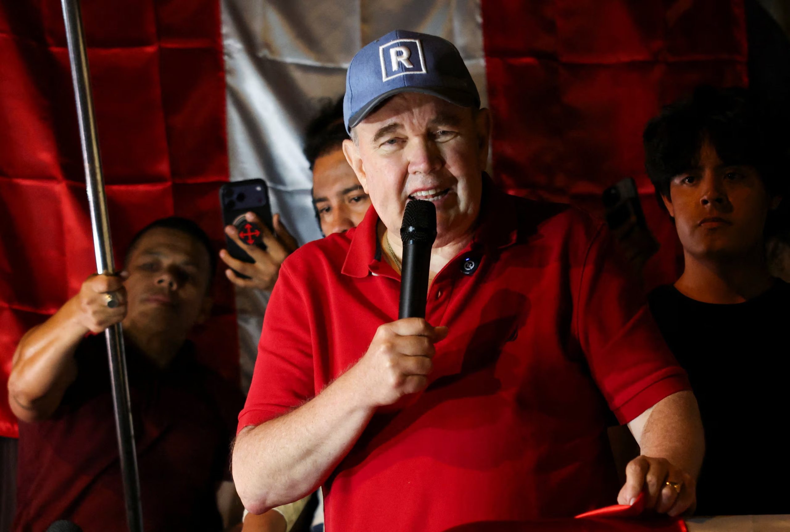 Peru's presidential candidate Rafael Lopez Aliaga speaks as people gather outside Peru's electoral headquarters amid concerns about the voting process during the country's general election, in Lima, Peru, April 14, March 2026. REUTERS/Manuel Orbegozo