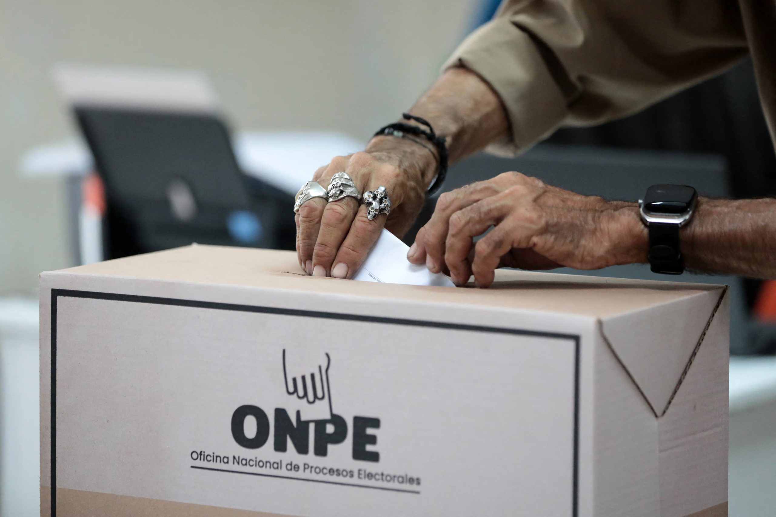 Un ciudadano deposita su papeleta de votación en la urna de la Oficina Nacional de Procesos Electorales (ONPE) durante las elecciones presidenciales en Perú, reflejando la participación democrática. (Agencia AFP)
