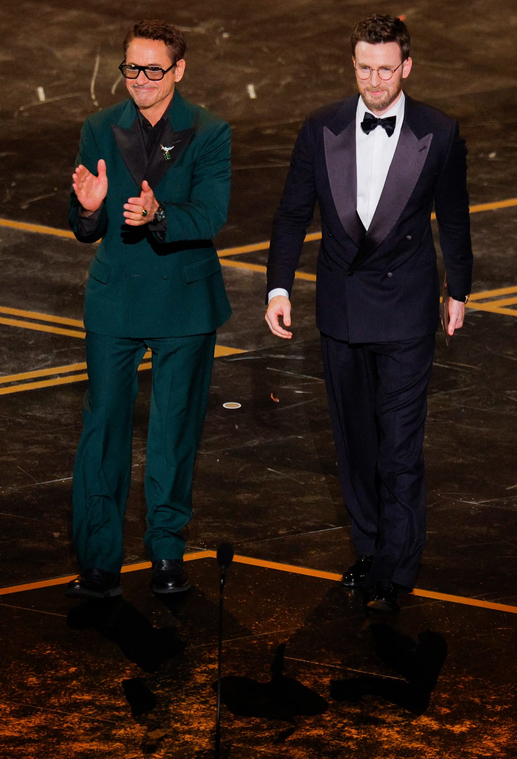 Traje verde oscuro de solapas satinadas con camisa negra y broche metálico en una gala (REUTERS/Mike Blake)