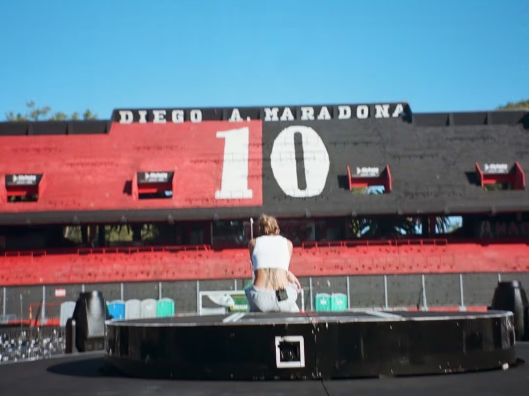 Tini Stoessel se prepara para su concierto en el estadio Diego Maradona de Rosario, con la emblemática tribuna y el número 10 de fondo.
