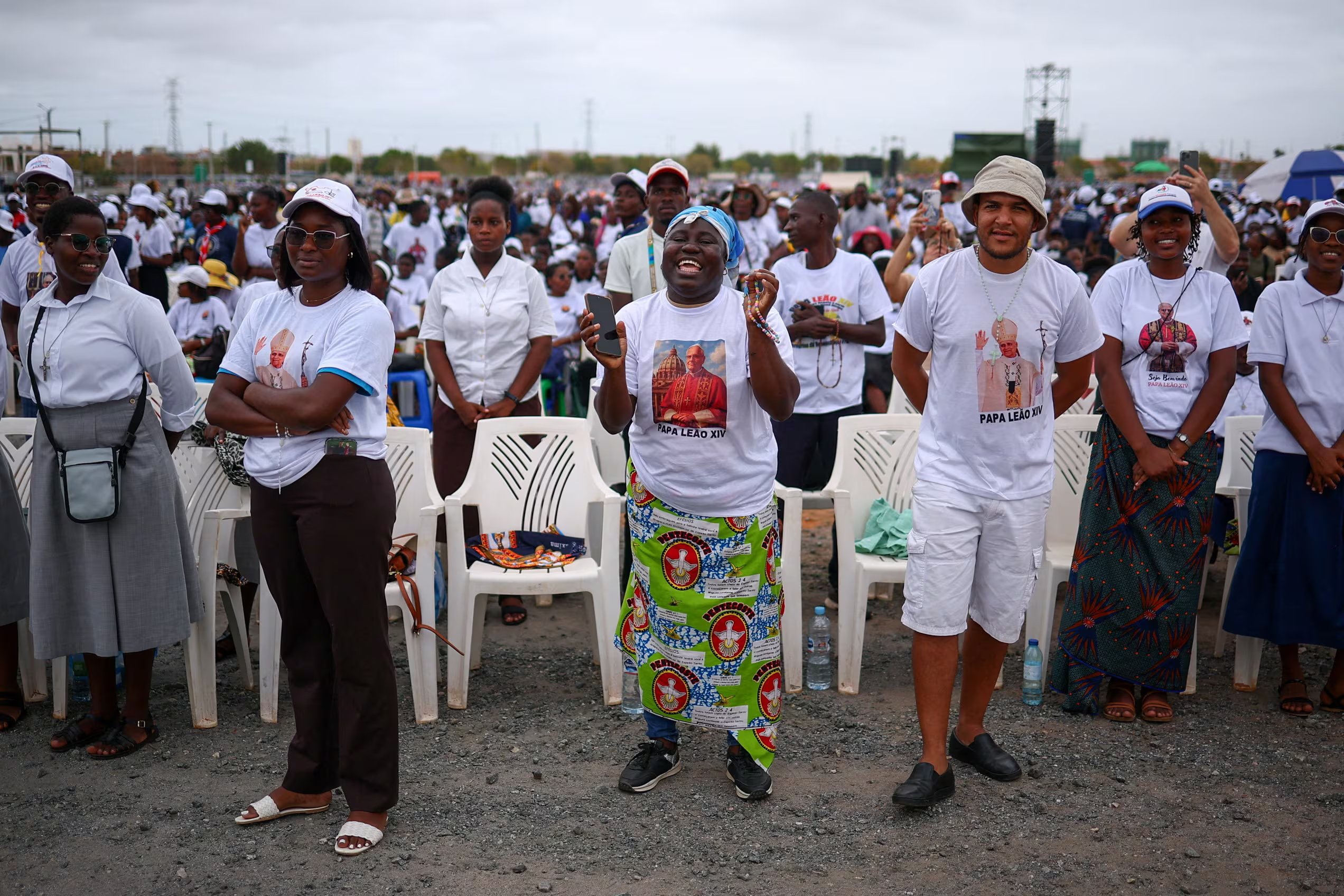 Fieles con camisetas con imágenes del Papa León XIV esperan el día en que el Papa oficiará la Santa Misa, durante su viaje apostólico por África, en Kilamba, provincia de Luanda, Angola, 19 de abril de 2026. REUTERS/Guglielmo Mangiapane