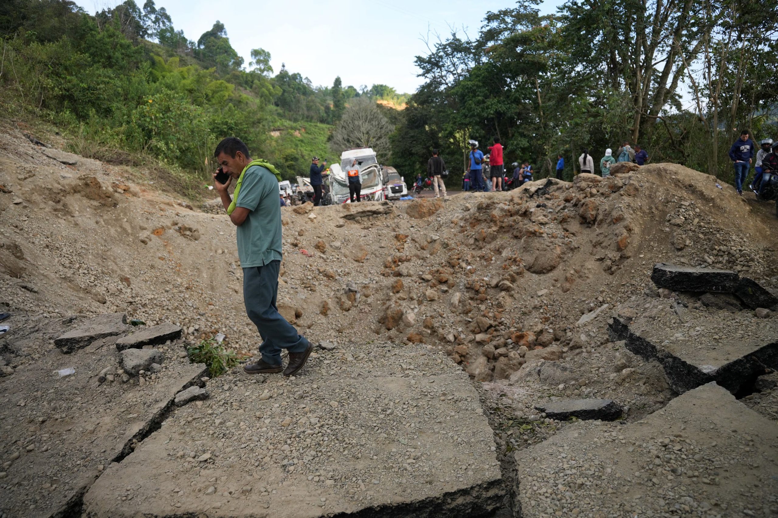 A man speaks on the phone next to a crater left by an attack with explosives that killed over a dozen people on the Pan-American Highway in the El Tunel area of Cajibio, Colombia April 26, 2026. REUTERS/Jair Coll