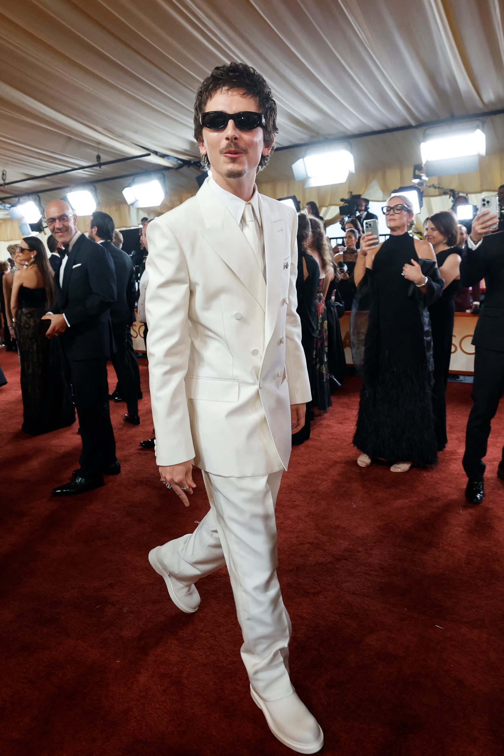 El conjunto monocromático en blanco, con saco clásico, camiseta y botas a juego, definió uno de los looks más armónicos y minimalistas de Timothée Chalamet (REUTERS/Carlos Barria)