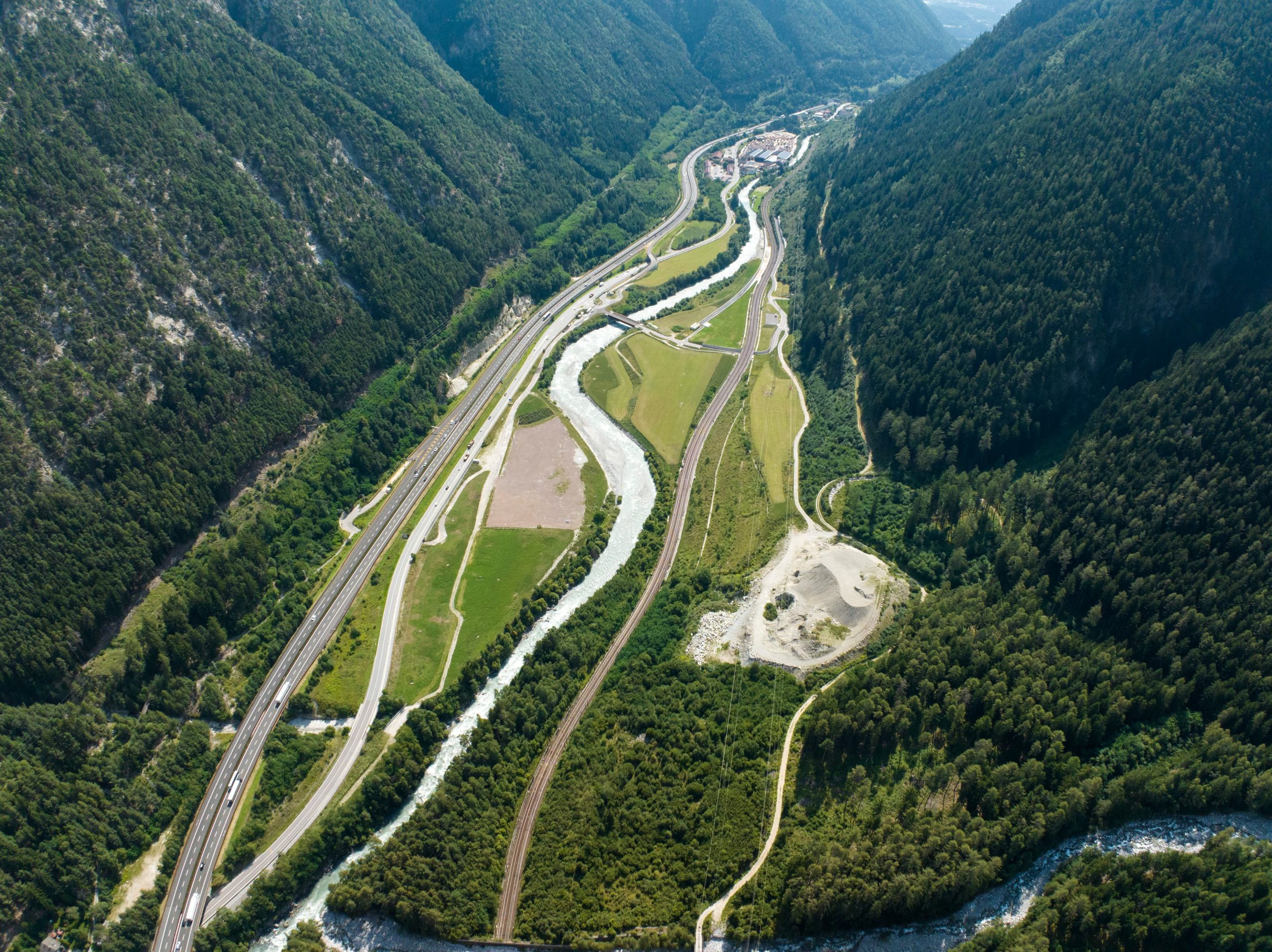 La compleja infraestructura de carreteras, ferrocarriles y el río Inn serpentea por el valle alpino, enmarcando las obras del Túnel de Base del Brenner, un proyecto clave para Europa
(© BBT SE)
