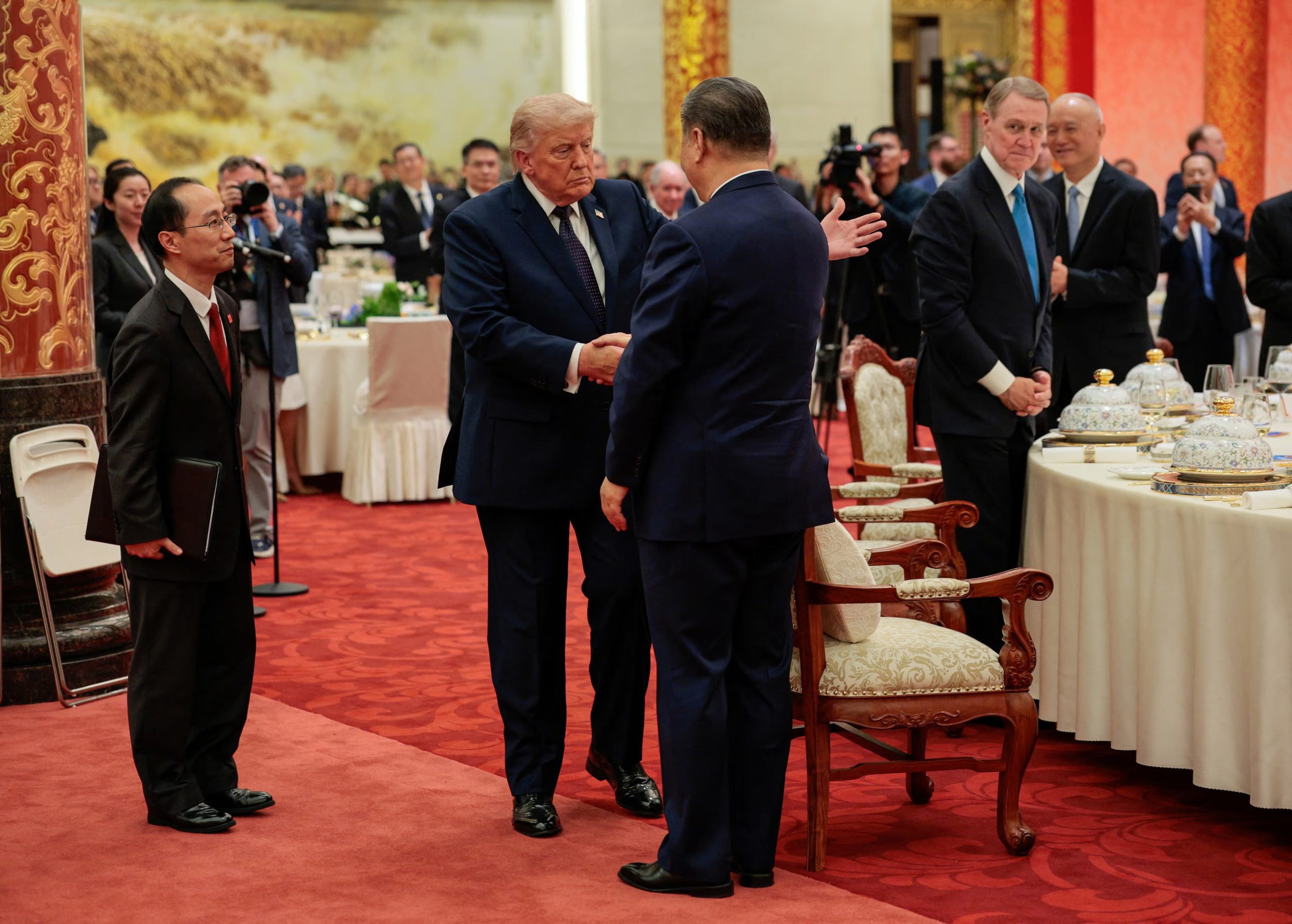 El presidente chino Xi Jinping y el presidente estadounidense Donald Trump se dan la mano en un banquete de Estado en el Gran Salón del Pueblo en Pekín, China, el 14 de mayo de 2026. REUTERS/Evan Vucci