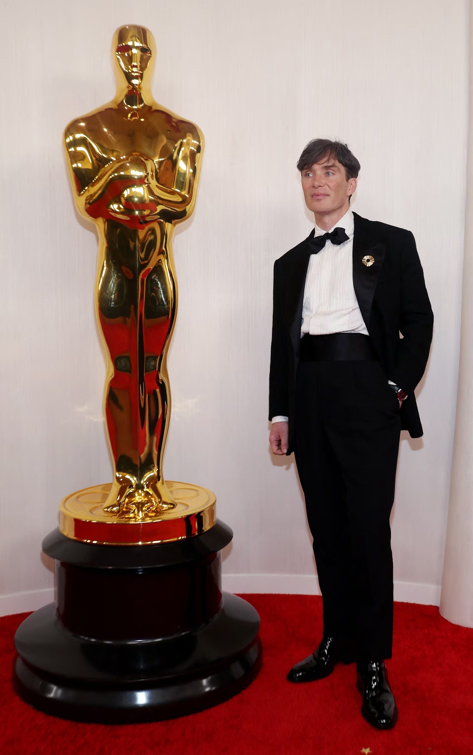 El esmoquin negro con moño suma un pin dorado como único detalle visible, con fajín negro, camisa con textura y zapatos de charol (REUTERS/Aude Guerrucci)