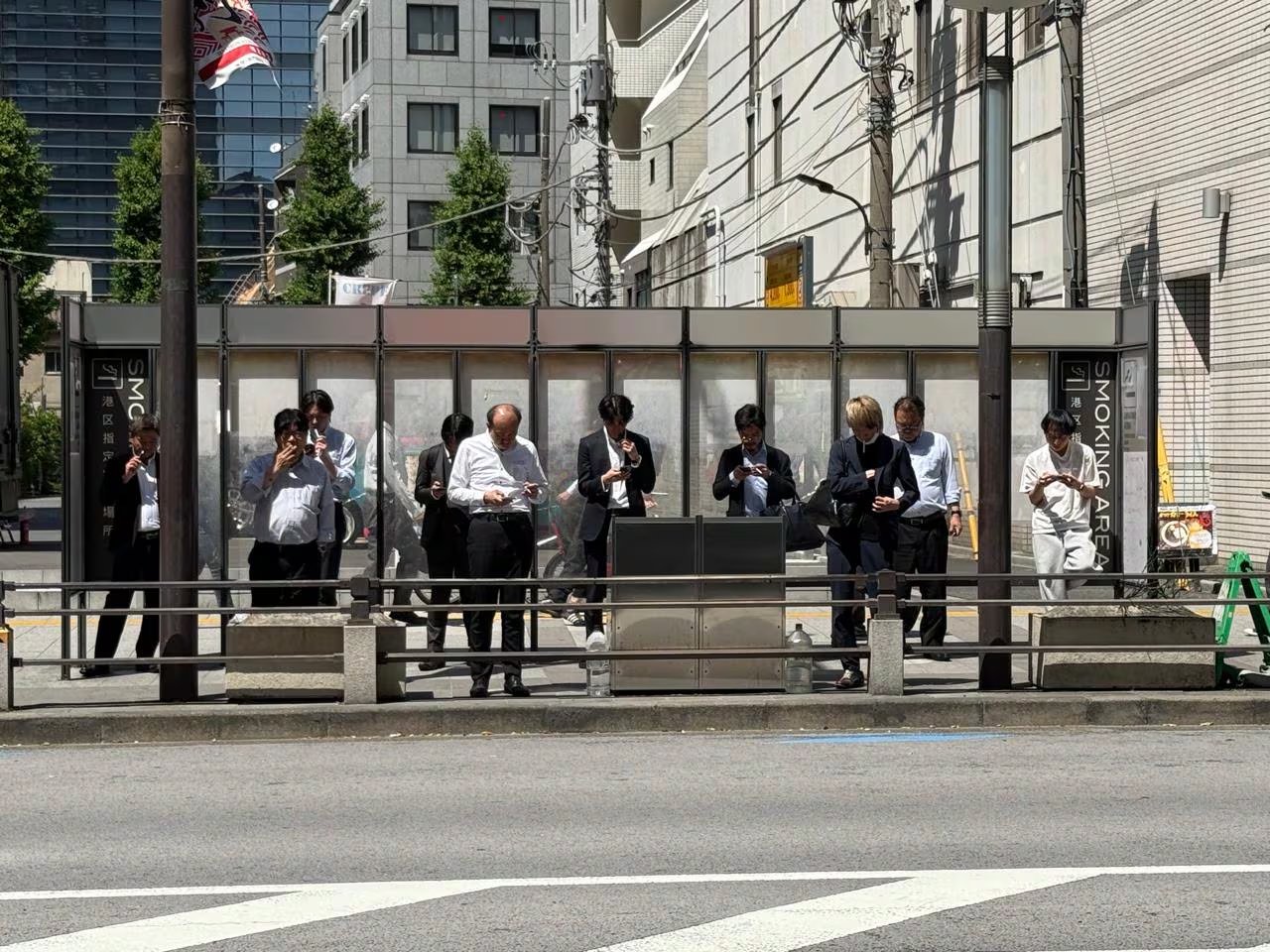 Residentes y trabajadores utilizan una zona de fumadores designada en una calle de Tokio, una práctica común que contribuye a mantener la limpieza y el orden en la ciudad. (Infobae)