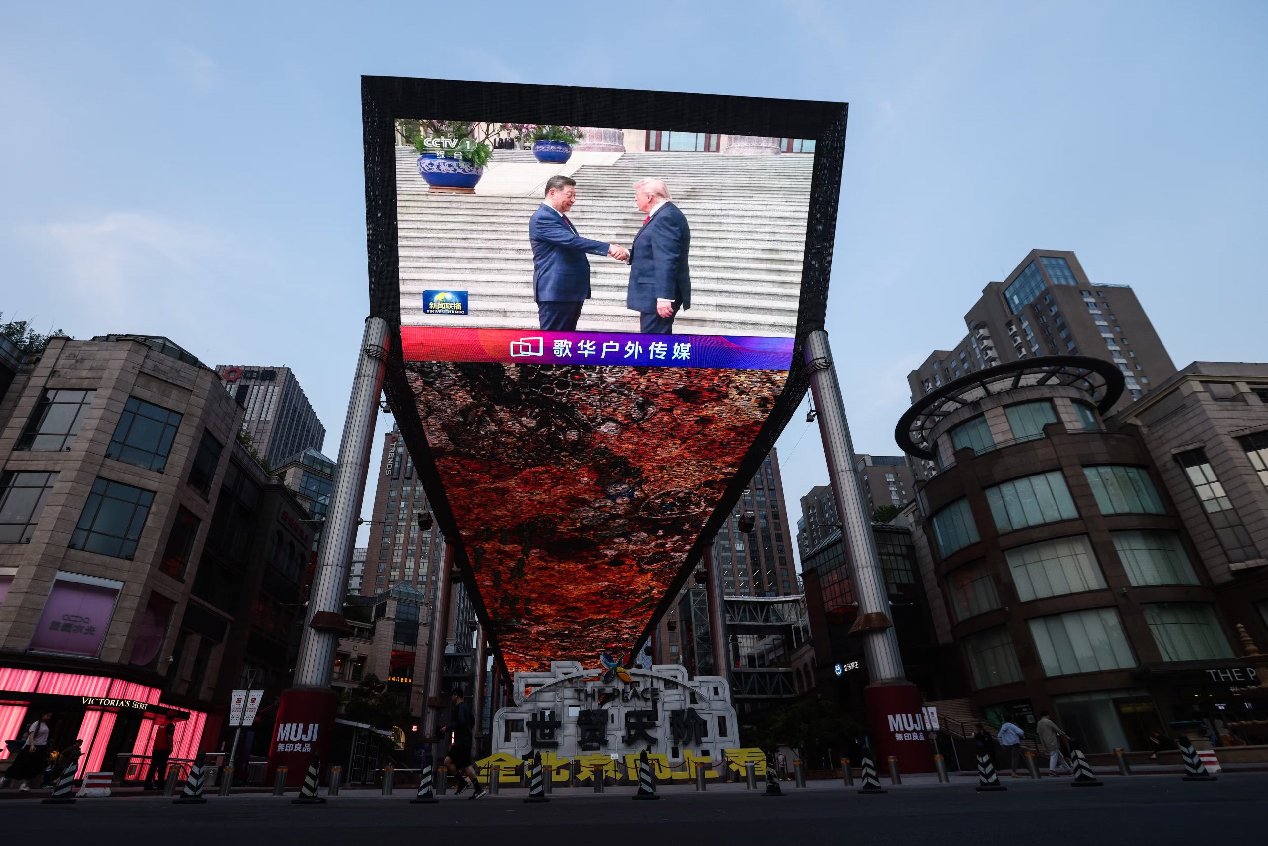 El presidente chino, Xi Jinping, y el presidente estadounidense, Donald Trump, se saludan en una pantalla gigante en Pekín (EFE/EPA/WU HAO)
