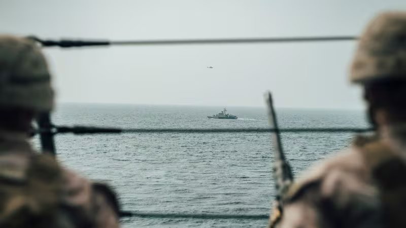 Infantes de Marina estadounidenses observan una lancha rápida de ataque iraní desde el buque USS John P. Murtha durante un recorrido por el estrecho de Ormuz (REUTERS/Archivo)