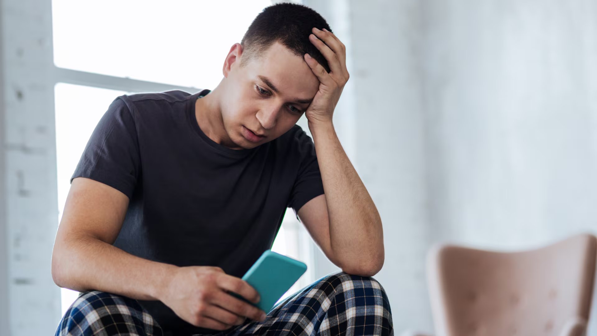 Un adolescente preocupado viendo su teléfono. (Canva)