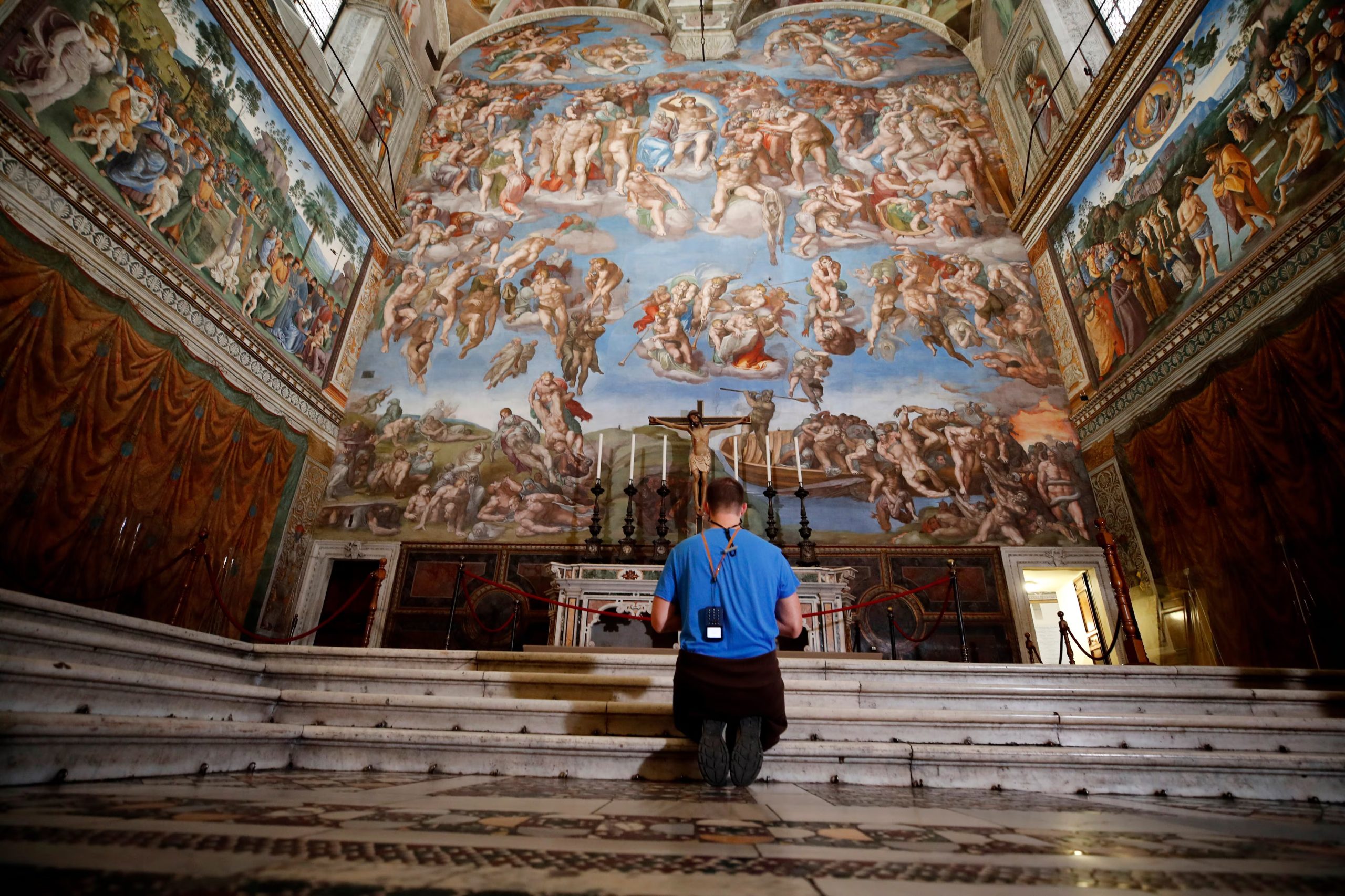 Un visitante se arrodilla frente al fresco del Juicio Final, obra del pintor italiano Miguel Ángel, dentro de la Capilla Sixtina (AP Foto/Alessandra Tarantino, Archivo)