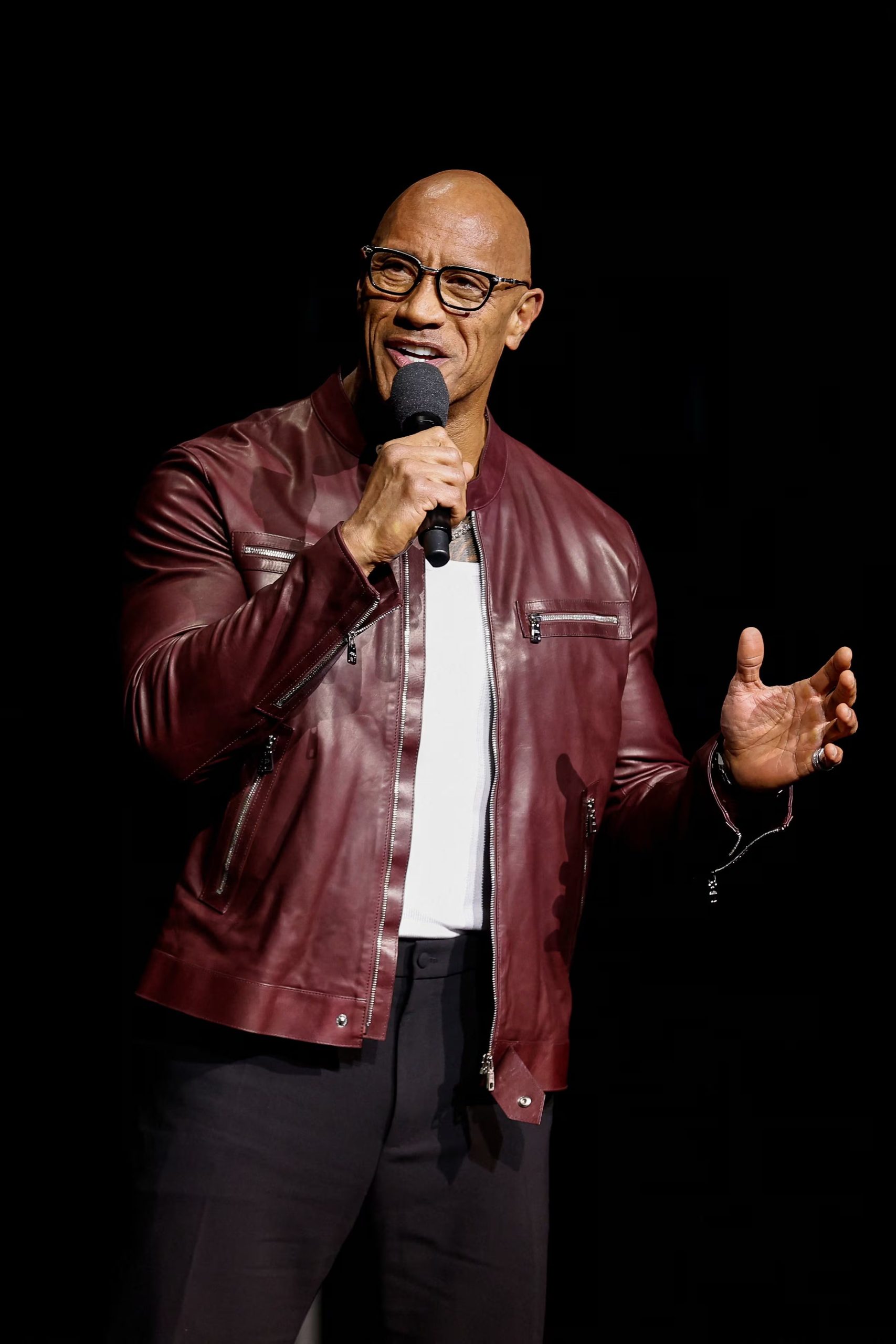 La chaqueta de cuero burdeos aporta un contraste urbano y audaz al estilo de Dwayne Johnson, resaltando su personalidad en escenarios nocturnos (REUTERS/Caroline Brehman)