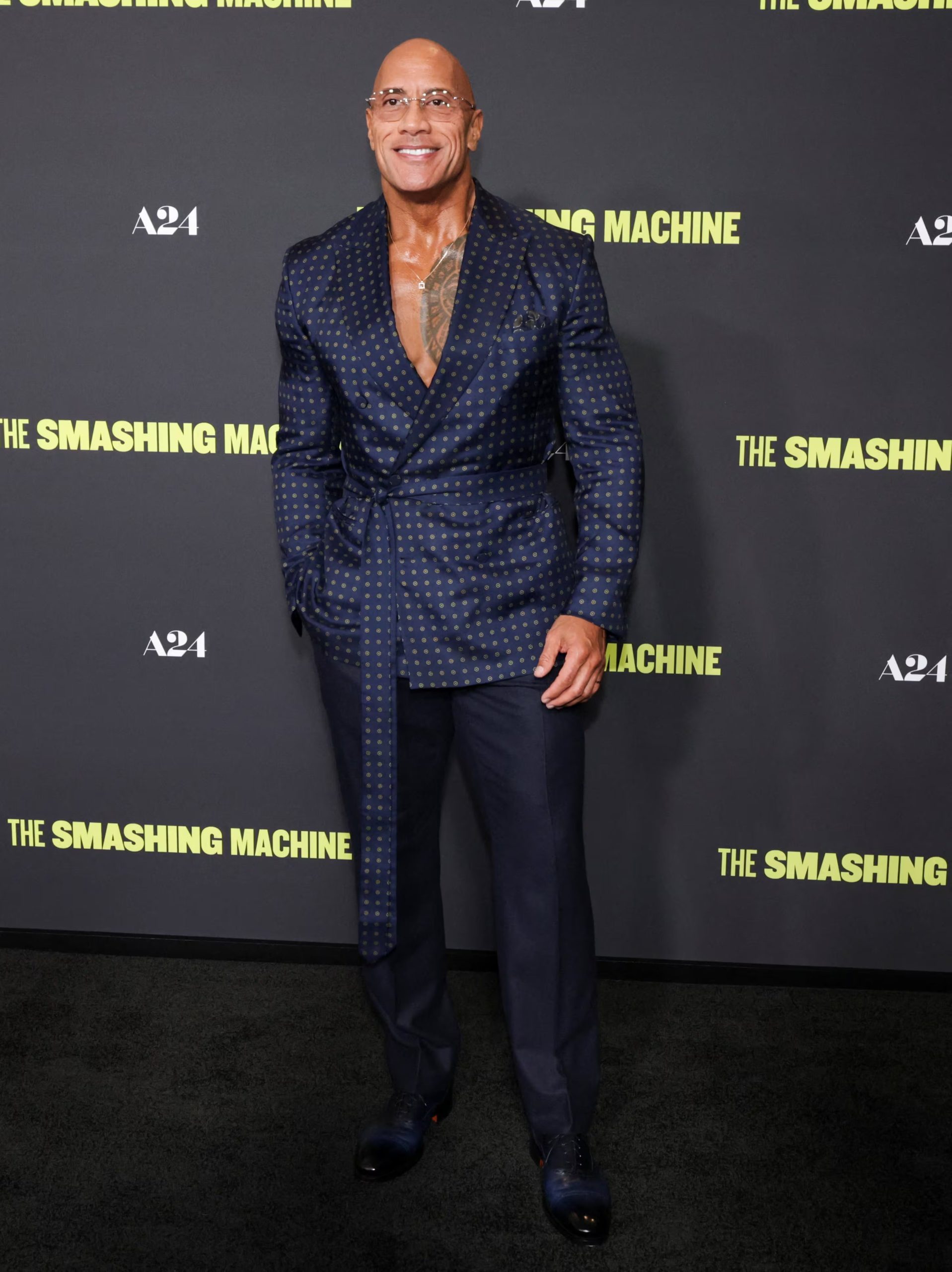 El traje azul oscuro con puntos dorados y corte batín destaca el carácter innovador de Dwayne Johnson en la moda masculina actual (REUTERS/Mario Anzuoni)