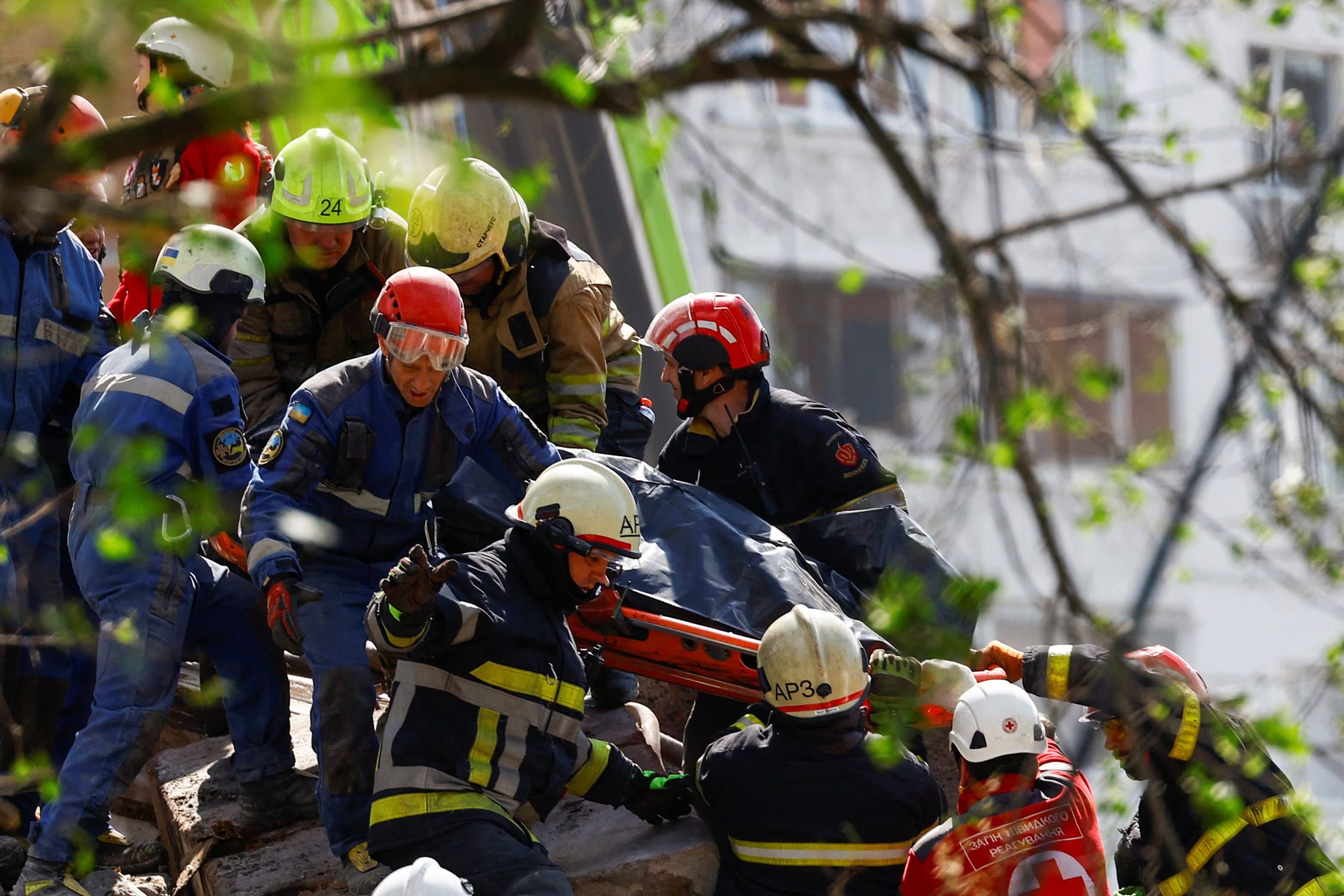 Rescatistas trasladan el cuerpo de una víctima recuperada entre los escombros de un edificio residencial alcanzado por el ataque ruso con drones y misiles sobre Kiev, el 14 de mayo de 2026. (REUTERS/Valentyn Ogirenko)