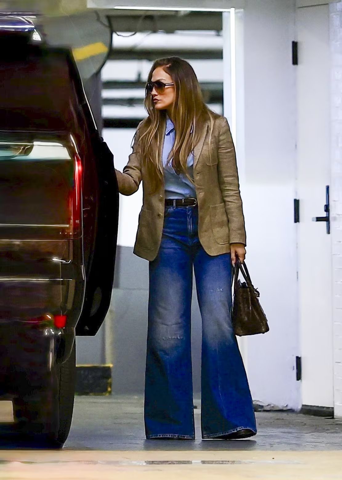 El blazer marrón y los vaqueros acampanados redefinen el estilo casual de Jennifer Lopez en sus salidas diarias (Backgrid/The Grosby Group)