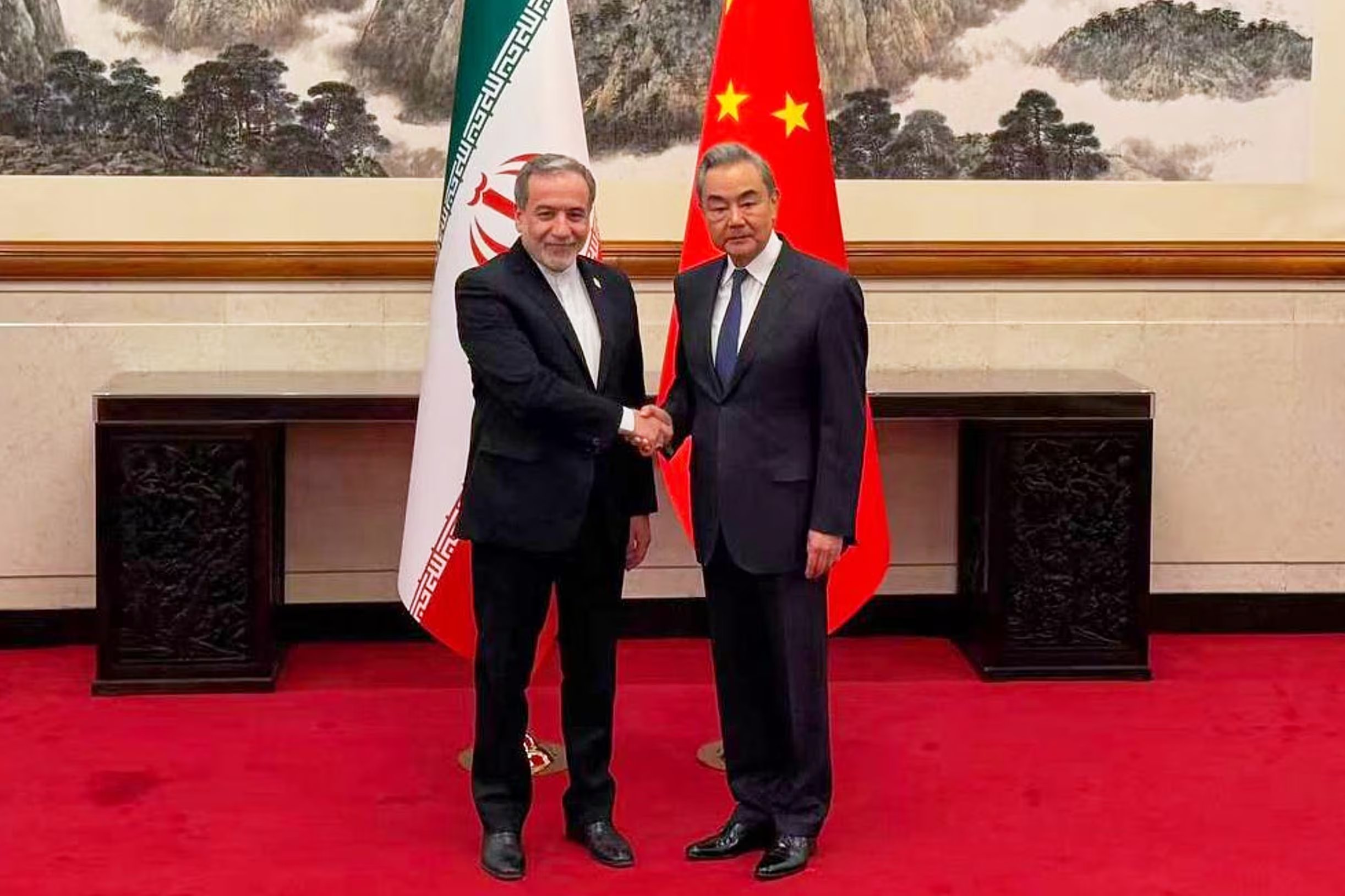 El ministro de Exteriores de Irán, Abbas Araghchi, saluda al ministro de Exteriores de China, Wang Yi, en Beijing (Canal de Telegram del ministro de Exteriores de Irán vía AP)
