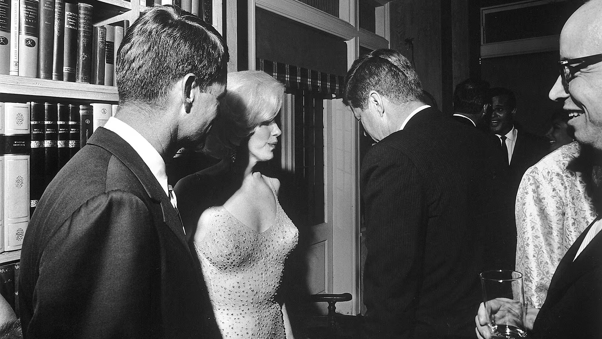 La única foto de Marilyn y John F. Kennedy juntos aquella noche del feliz cumpleaños. La imagen fue registrada en la recepción posterior a la reunión en el Madison Square Garden. Kennedy está de espaldas frente a Marilyn Monroe