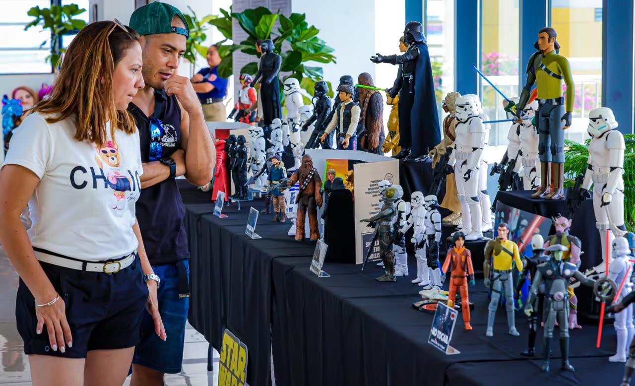 Una pareja observa con interés una vasta colección de figuras de acción de Star Wars en una exhibición capitalina. (Foto cortesía Secretaría de Prensa de la Presidencia)
