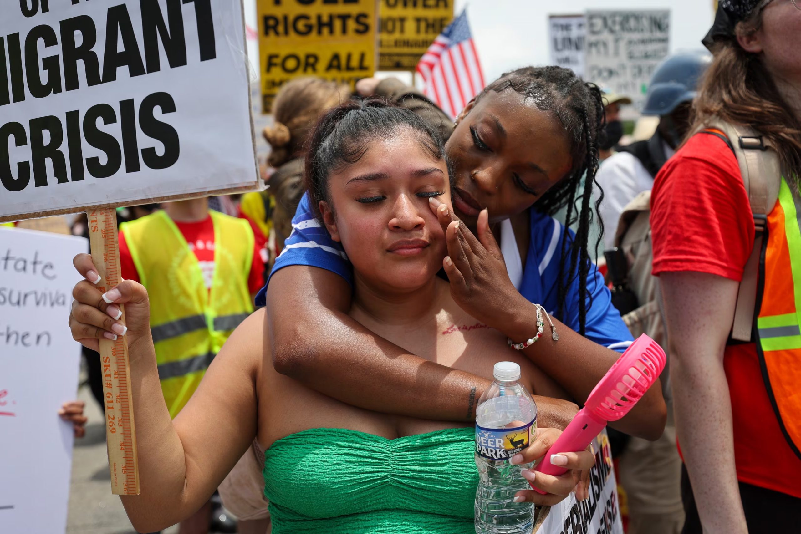 Daisy Morán, a la izquierda, y Constance Felton participan en una protesta contra las redadas del ICE y las detenciones para deportación, mientras la policía bloquea su marcha en Chamblee Tucker Road, en Atlanta, el sábado 14 de junio de 2025. (Arvin Temkar/Atlanta Journal-Constitution vía AP)