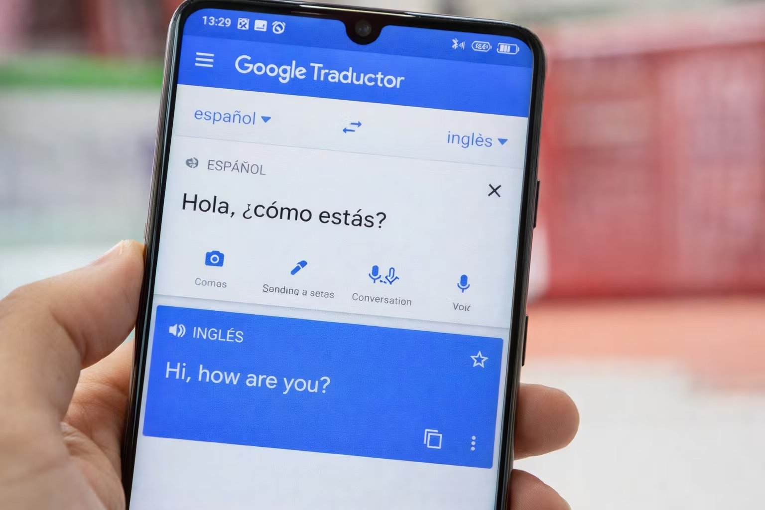 Una mano sostiene un teléfono móvil mostrando la interfaz de Google Traductor. (Imagen Ilustrativa Infobae)