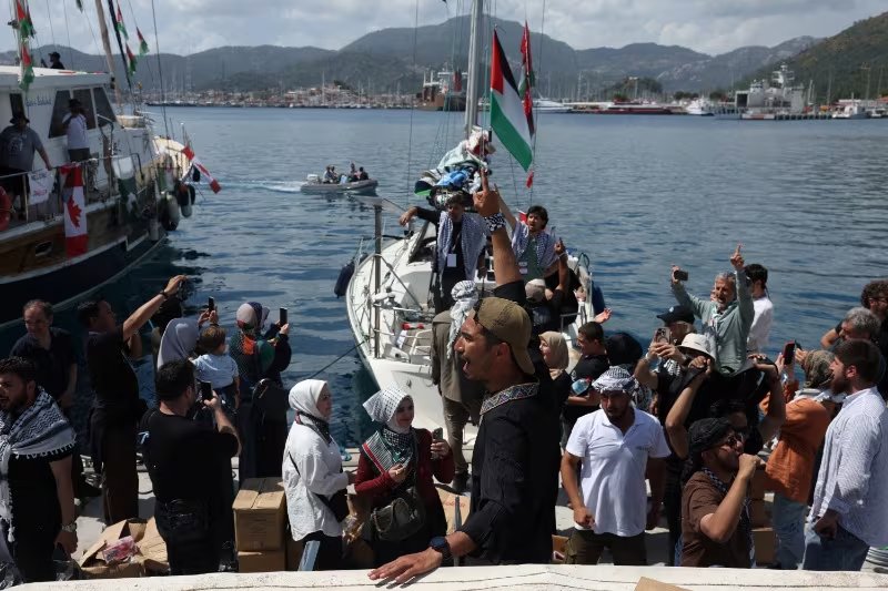 Activistas saludan desde uno de los barcos de la Global Sumud Flotilla al zarpar del puerto de Marmaris, en el sur de Turquía, el 14 de mayo. La misión llevaba a bordo a 430 activistas, entre ellos 29 italianos (REUTERS/Dilara Senkaya)