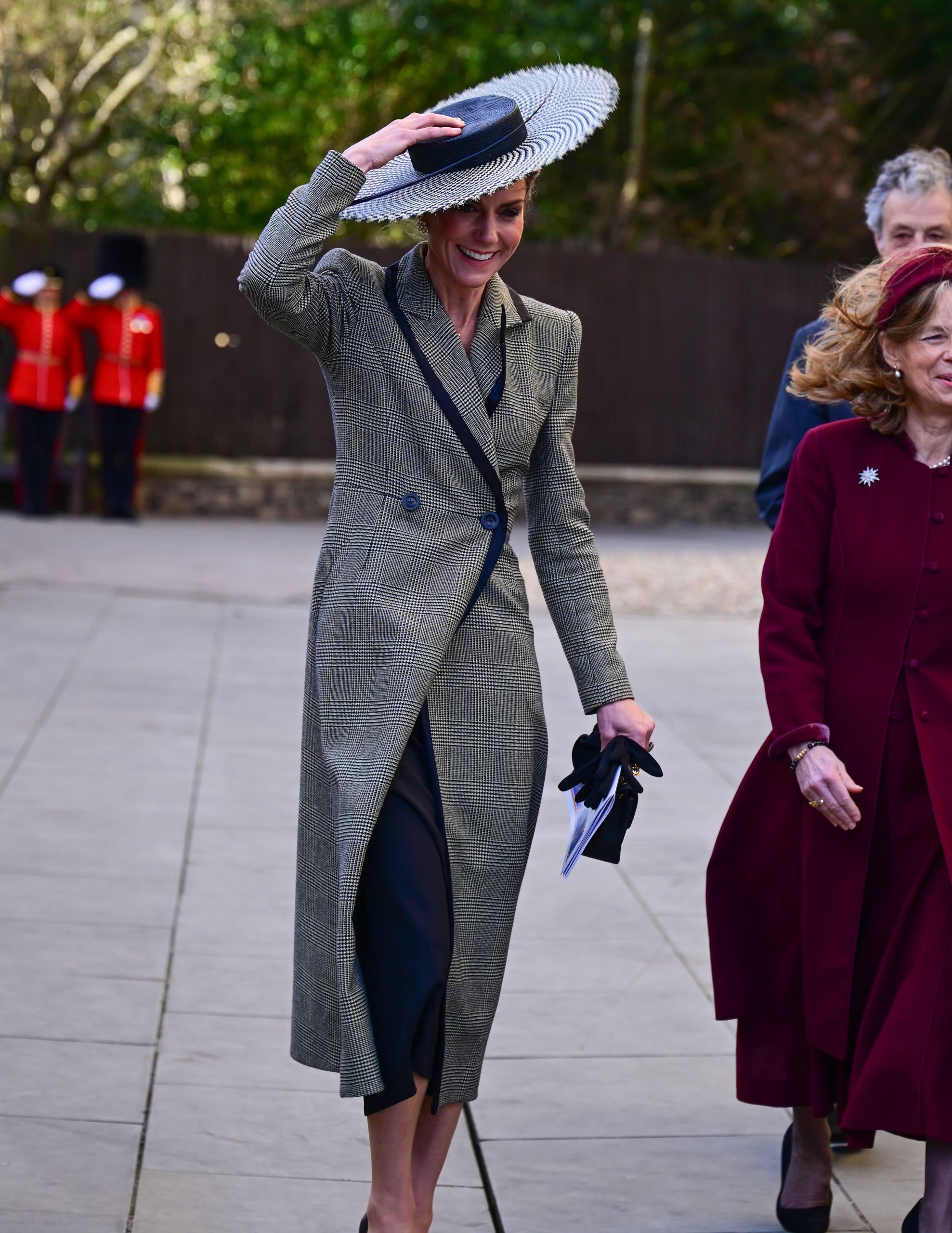 El abrigo de cuadros gris, el sombrero bicolor con velo y los guantes oscuros reflejaron la capacidad de Kate Middleton para combinar funcionalidad y moda (Grosby)