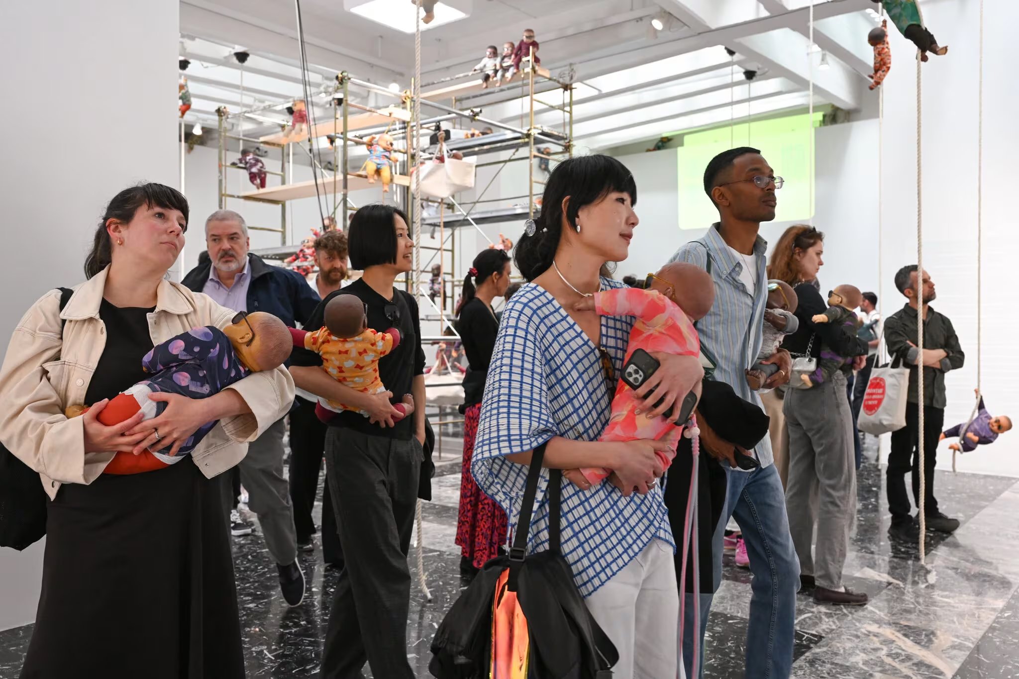 Los visitantes llevan las muñecas consigo a lo largo de la exposición y las conducen a un cambiador para recibir un poema personalizado (Crédito: Casey Kelbaugh para The New York Times)