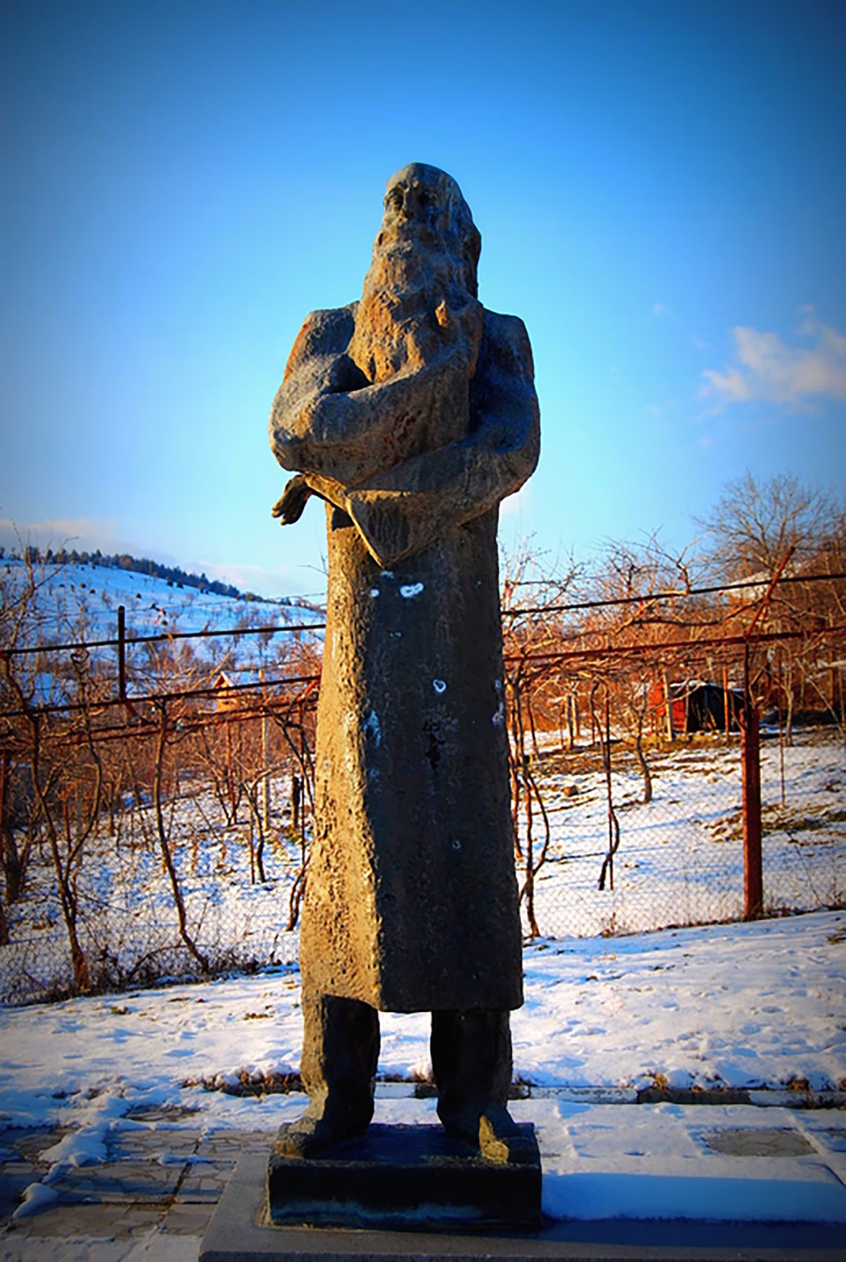 La imponente estatua en Frolosh de Vladimir Dimitrov - El Maestro, se alza majestuosamente rodeada por un paisaje invernal cubierto de nieve