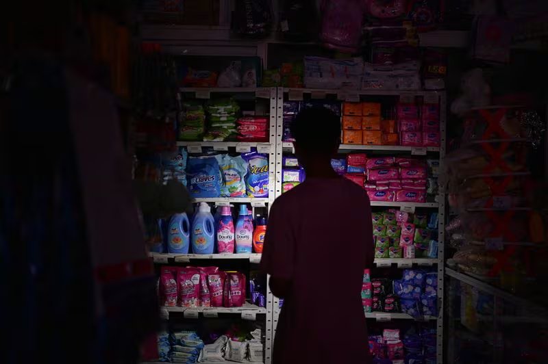 Un hombre utiliza la luz de su teléfono móvil en una tienda sin electricidad durante un apagón que afecta a Caracas y otras regiones del país, en Caracas, Venezuela. 30 de agosto 2024. REUTERS/Gaby Oraa - RC2MQ9AFBTYP
