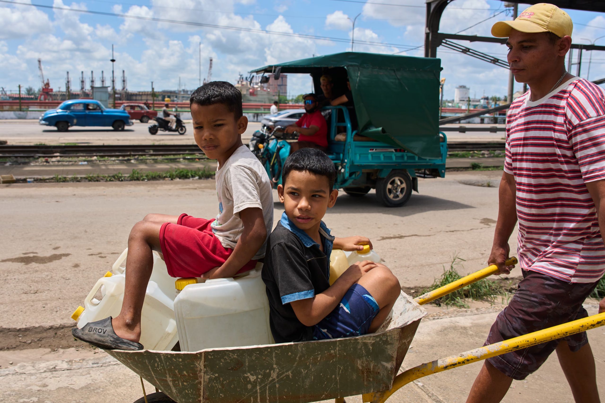 Un hombre transporta bidones de agua con sus hijos en La Habana, el jueves 28 de mayo de 2026 (AP/Ramon Espinosa)