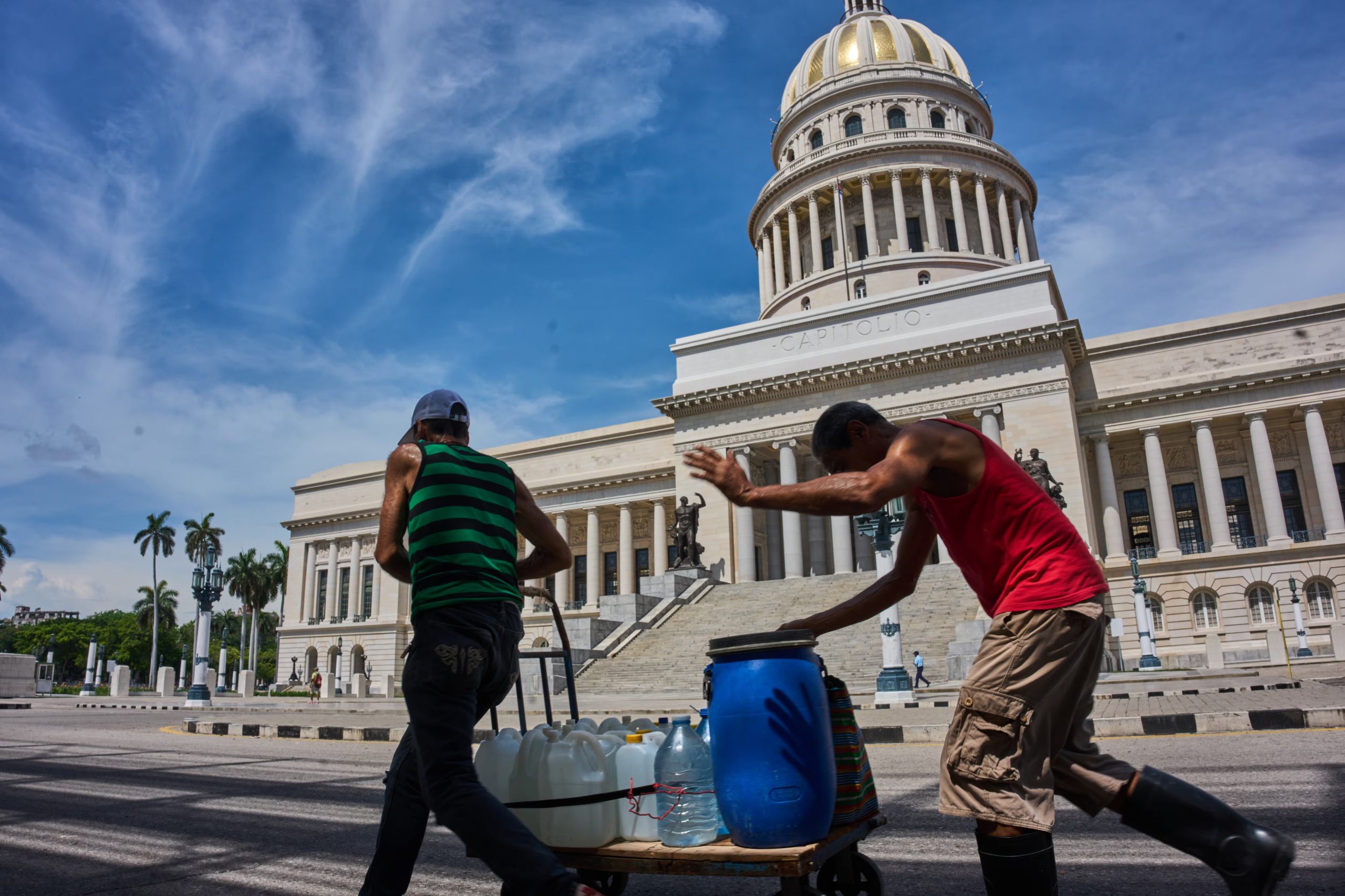 Personas transportan bidones de agua frente al Capitolio en La Habana, el miércoles 27 de mayo de 2026 (AP/Ramon Espinosa)