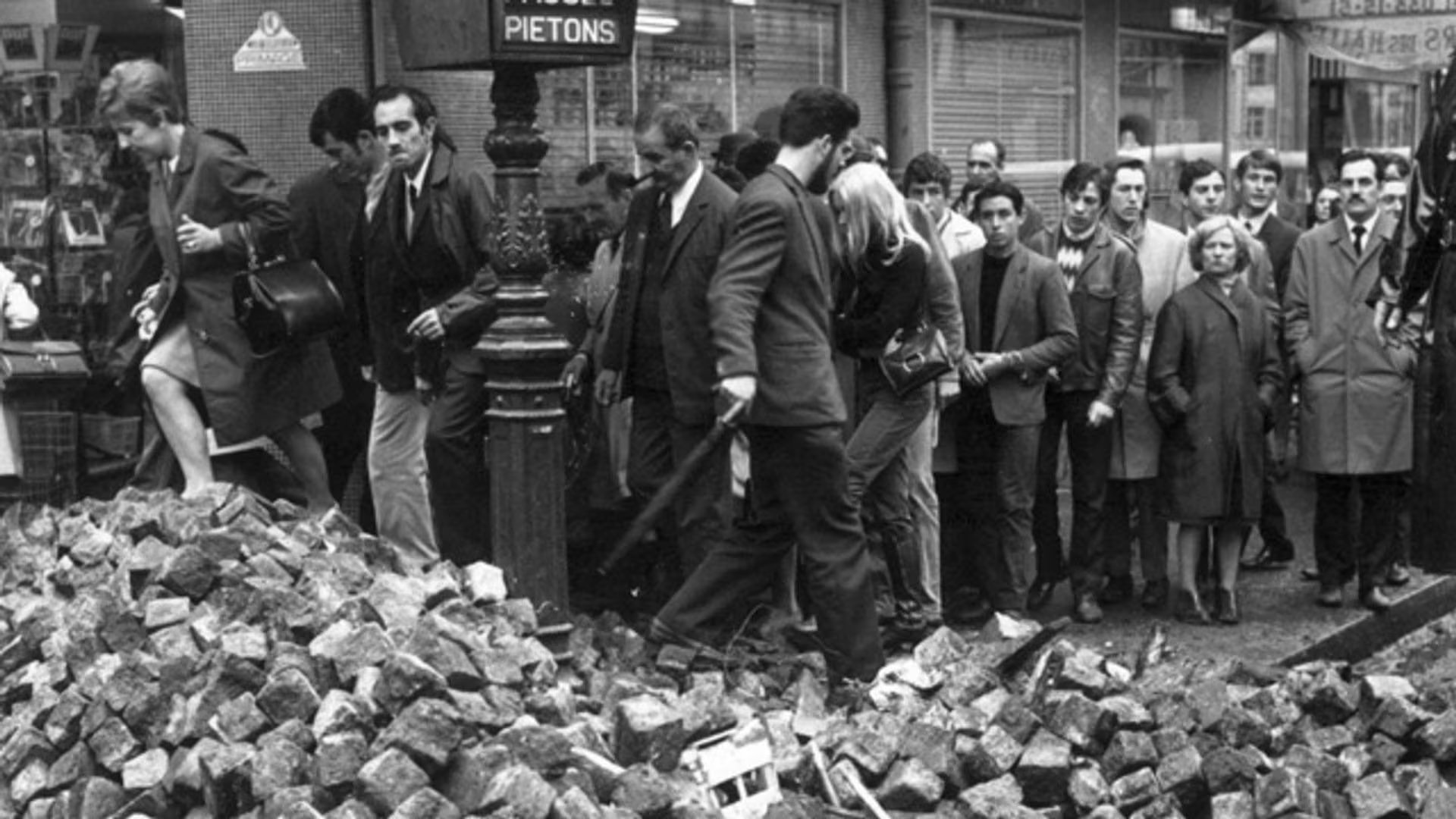 Gente que camina sobre una de las barricadas de adoquines 