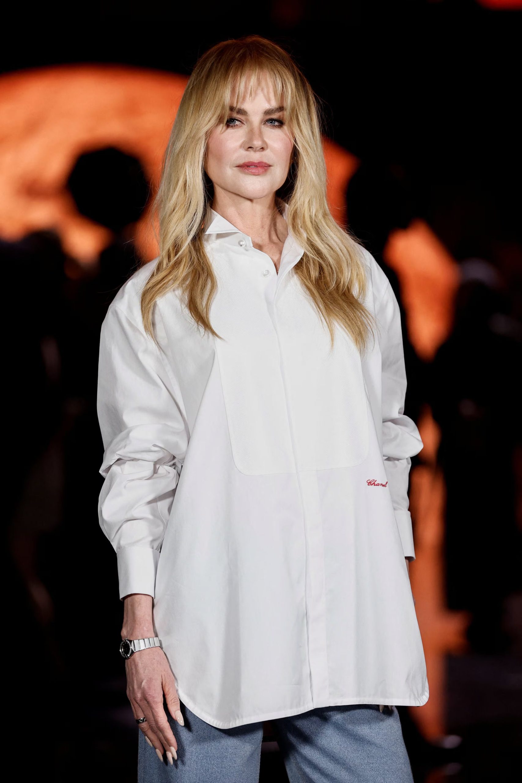 La camisa blanca oversize con detalles de marca, como la placa y el bordado “Chanel”, elegida por Nicole Kidman fusiona volumen, modernidad y exclusividad en un solo look (REUTERS/Benoit Tessier)