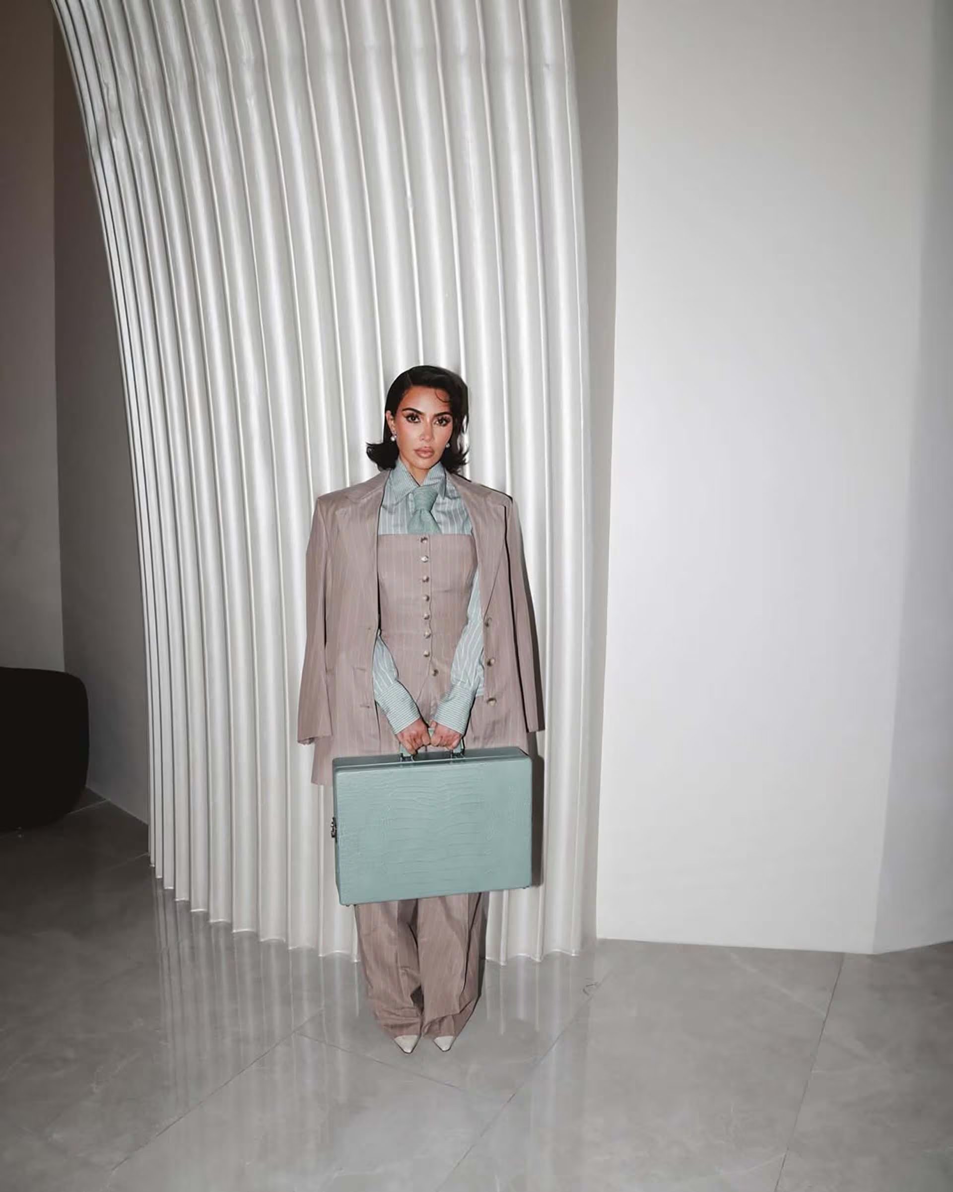 La camisa celeste con rayas finas, combinada en un conjunto monocromático y estructurado, posiciona a Kim Kardashian como referente de la estética geométrica y pulida en la moda urbana (IG Kim Kardashian)