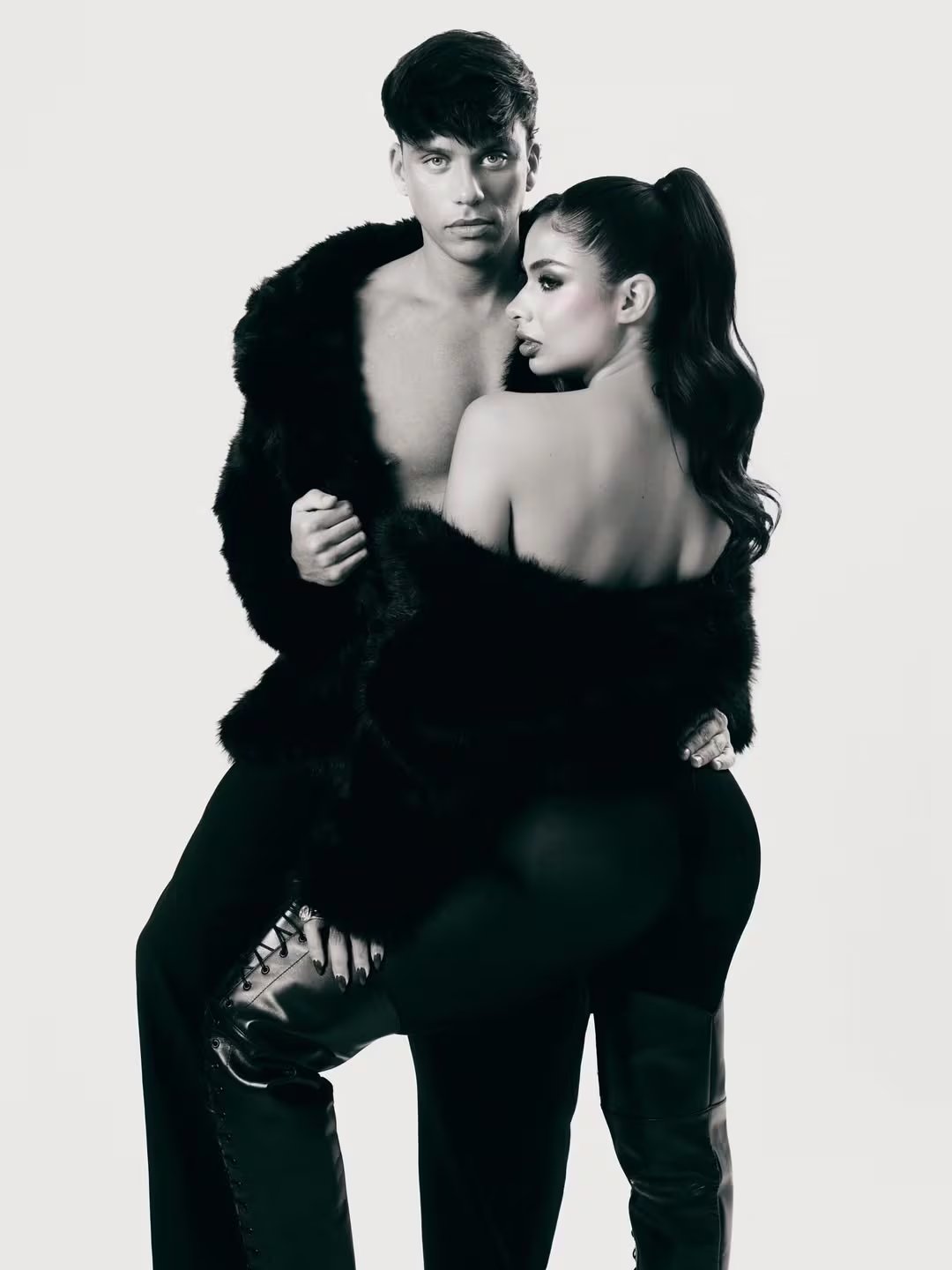 Daniela Celis y Nick Sicaro posan juntos en una poderosa sesión fotográfica en blanco y negro, luciendo abrigos de piel y un estilo audaz.