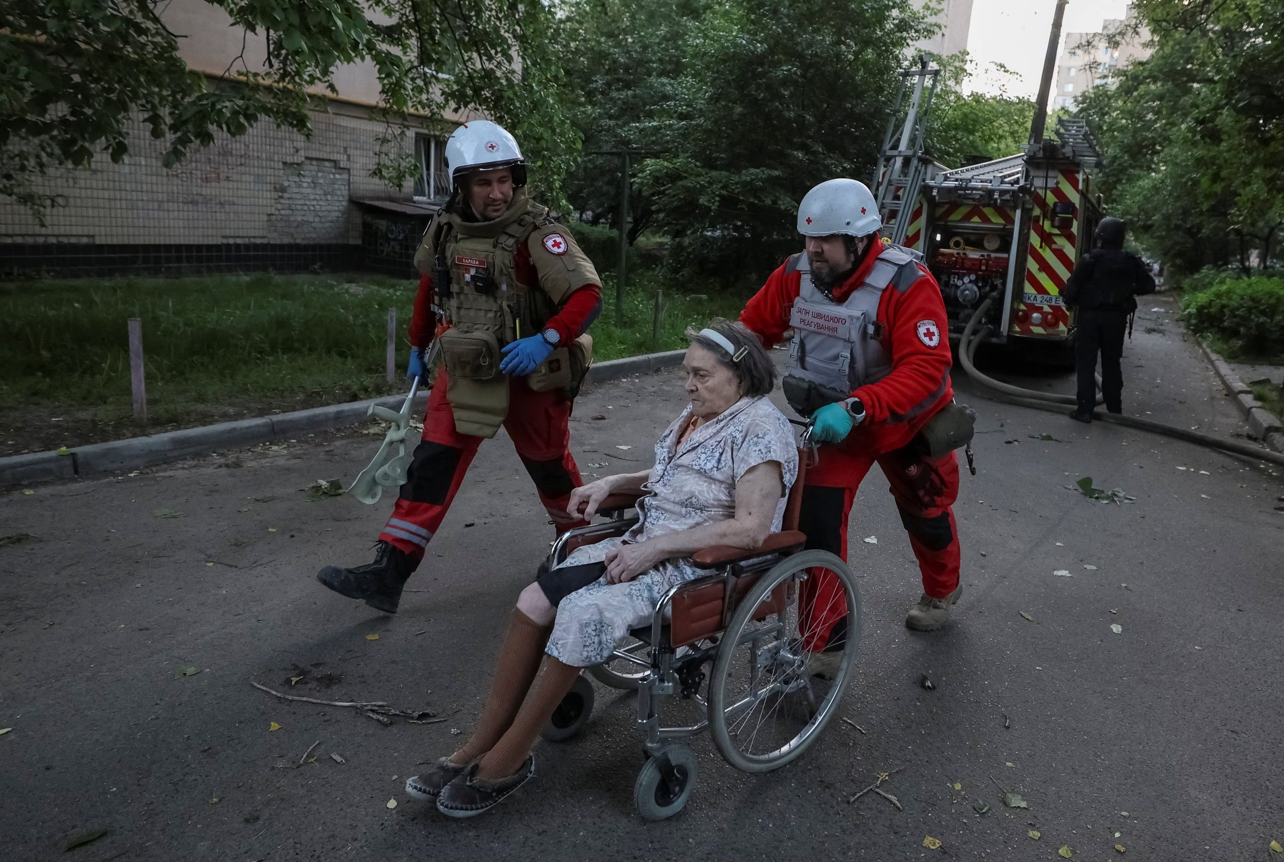 Personal sanitario evacúa a una mujer en el lugar donde un edificio de apartamentos fue destruido por un ataque con misiles y drones rusos.