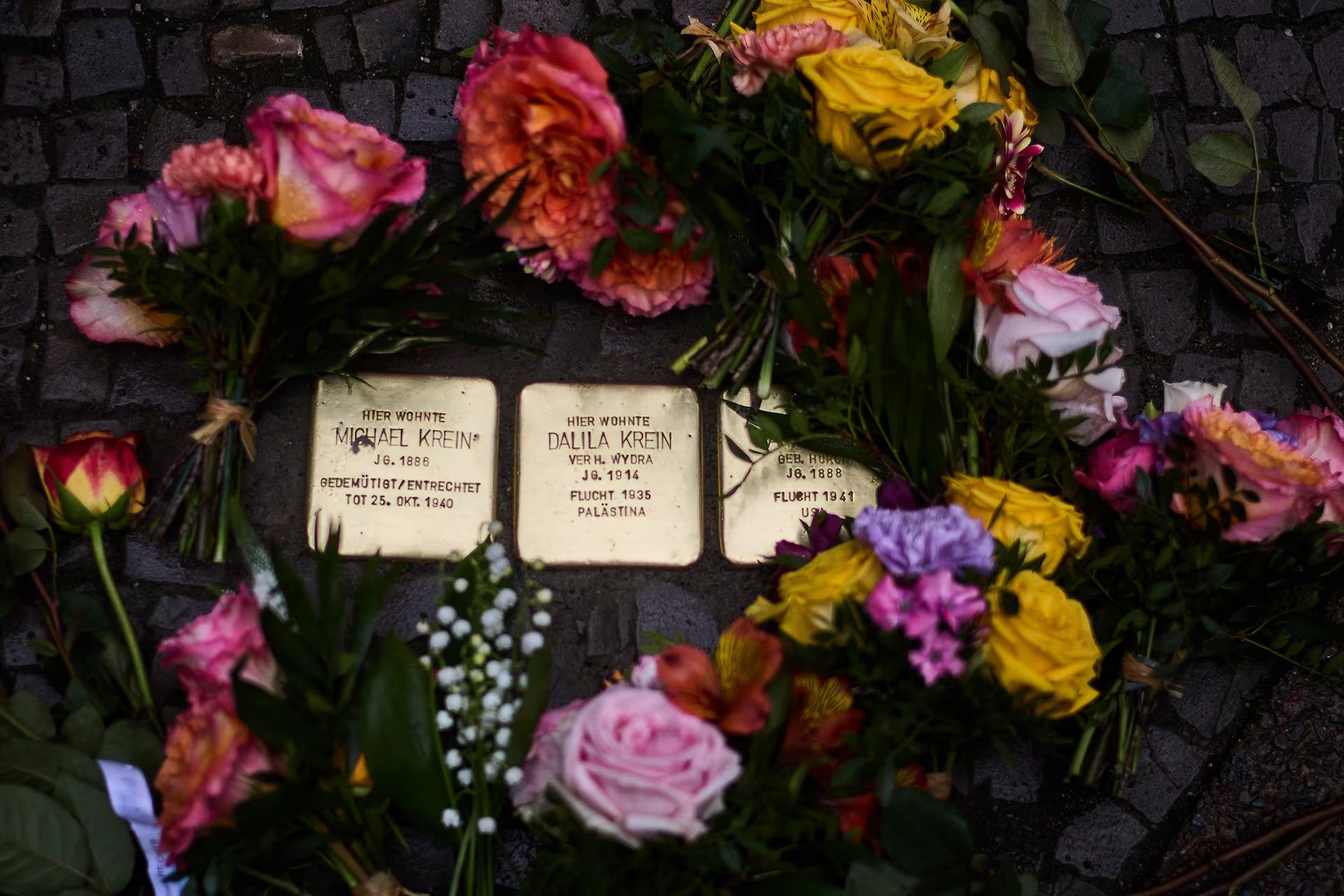Ramos de flores coloridas adornan las Stolpersteine, los adoquines conmemorativos que rinden homenaje a las víctimas de la persecución nazi en Europa. (AP)