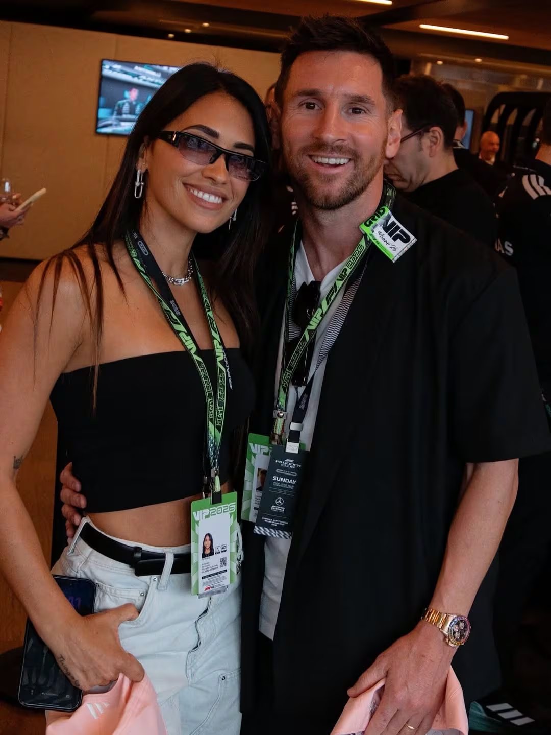 Antonela Roccuzzo y Lionel Messi posan sonrientes en el Gran Premio de Miami, disfrutando de la emoción de la Fórmula 1.