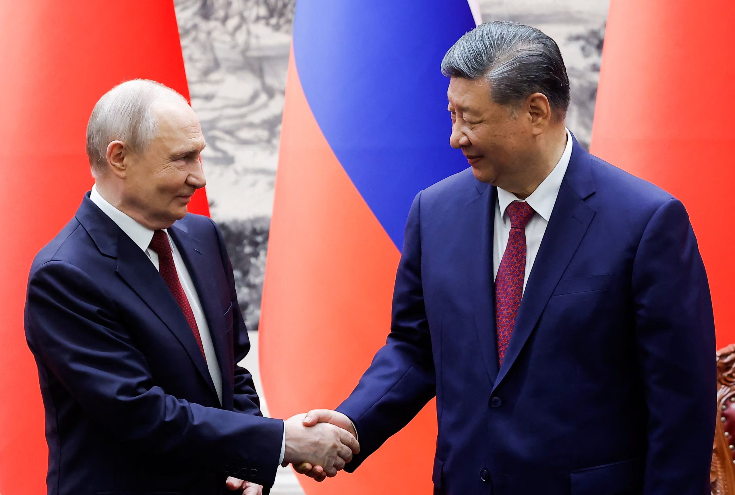 El presidente ruso Vladimir Putin y el presidente chino Xi Jinping se dan la mano durante una ceremonia de firma en el Gran Salón del Pueblo en Pekín, China, el 20 de mayo de 2026. REUTERS/Maxim Shemetov/Pool