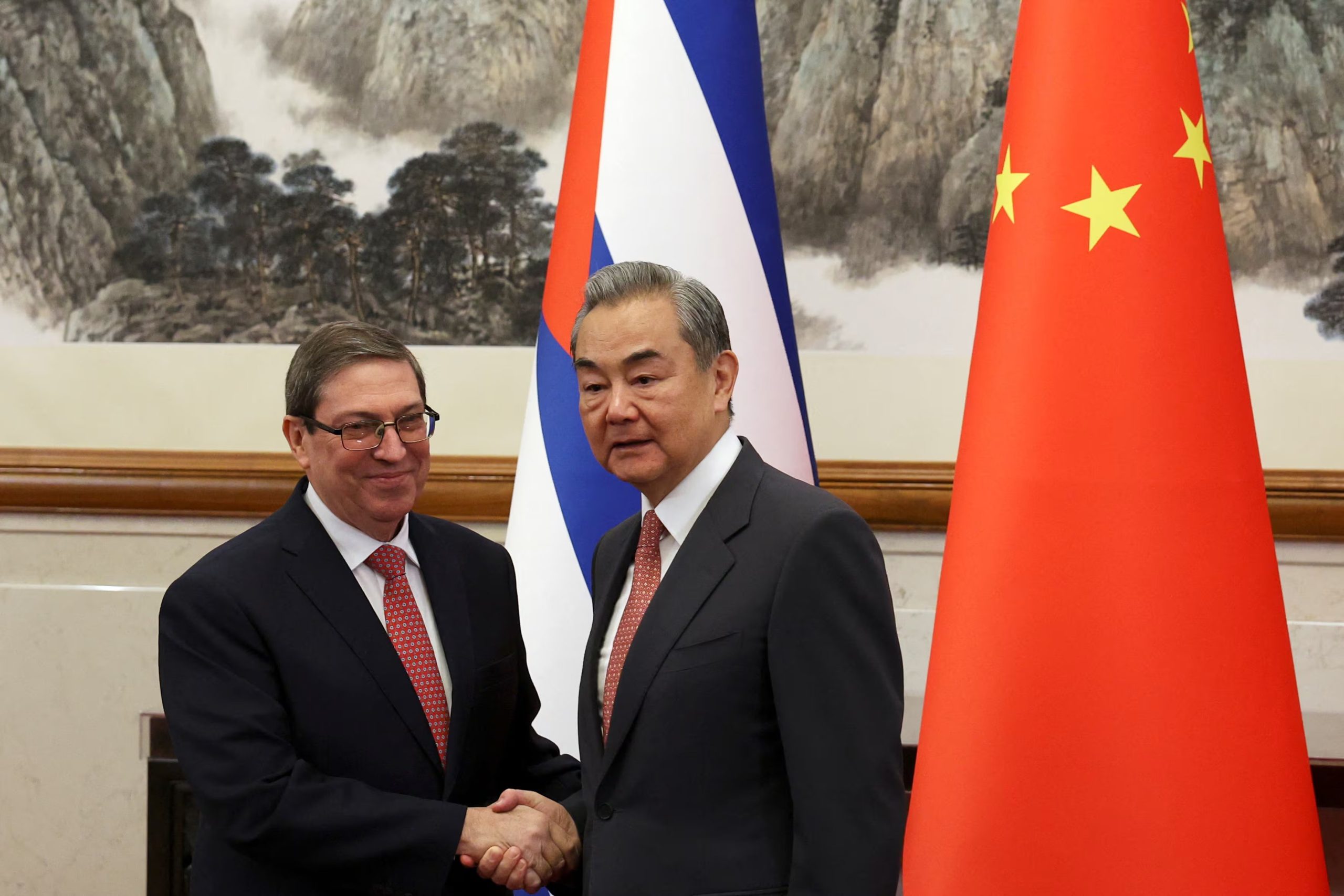 El ministro de Asuntos Exteriores chino, Wang Yi, y el ministro de Asuntos Exteriores cubano, Bruno Rodríguez Parrilla, se dan la mano antes de su reunión en la Residencia Oficial de Huéspedes de Diaoyutai, en Beijing (China), el 12 de mayo de 2025 (REUTERS/Florence Lo/Archivo)