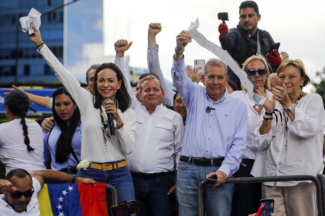María Corina Machado y Edmundo González Urrutia saludan a sus simpatizantes en un evento de campaña en Venezuela, mostrando unidad de cara a las próximas elecciones