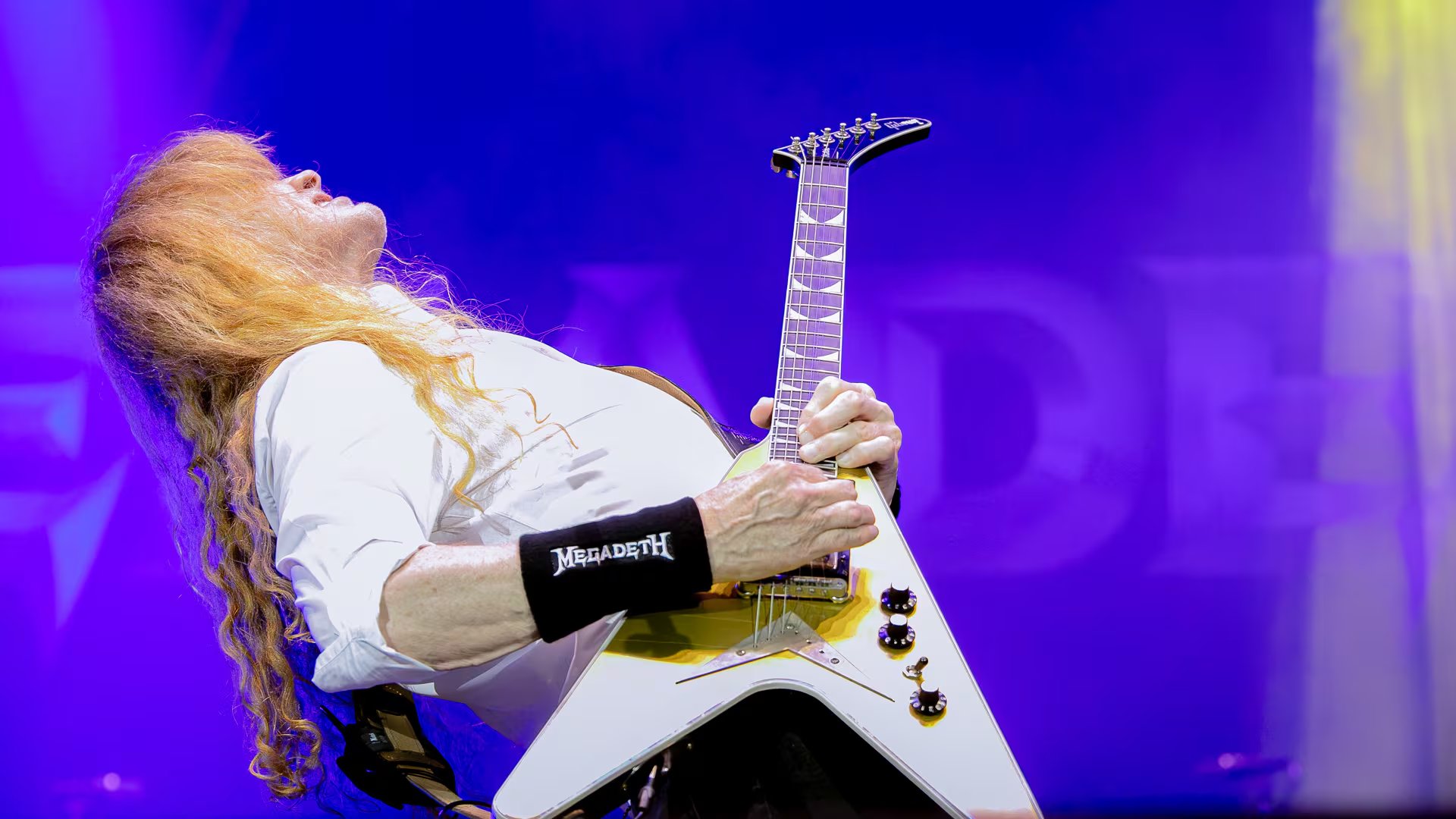 Dave Mustaine de Megadeth, con su característica cabellera rojiza, interpreta la guitarra en el escenario durante su enérgica presentación en Argentina