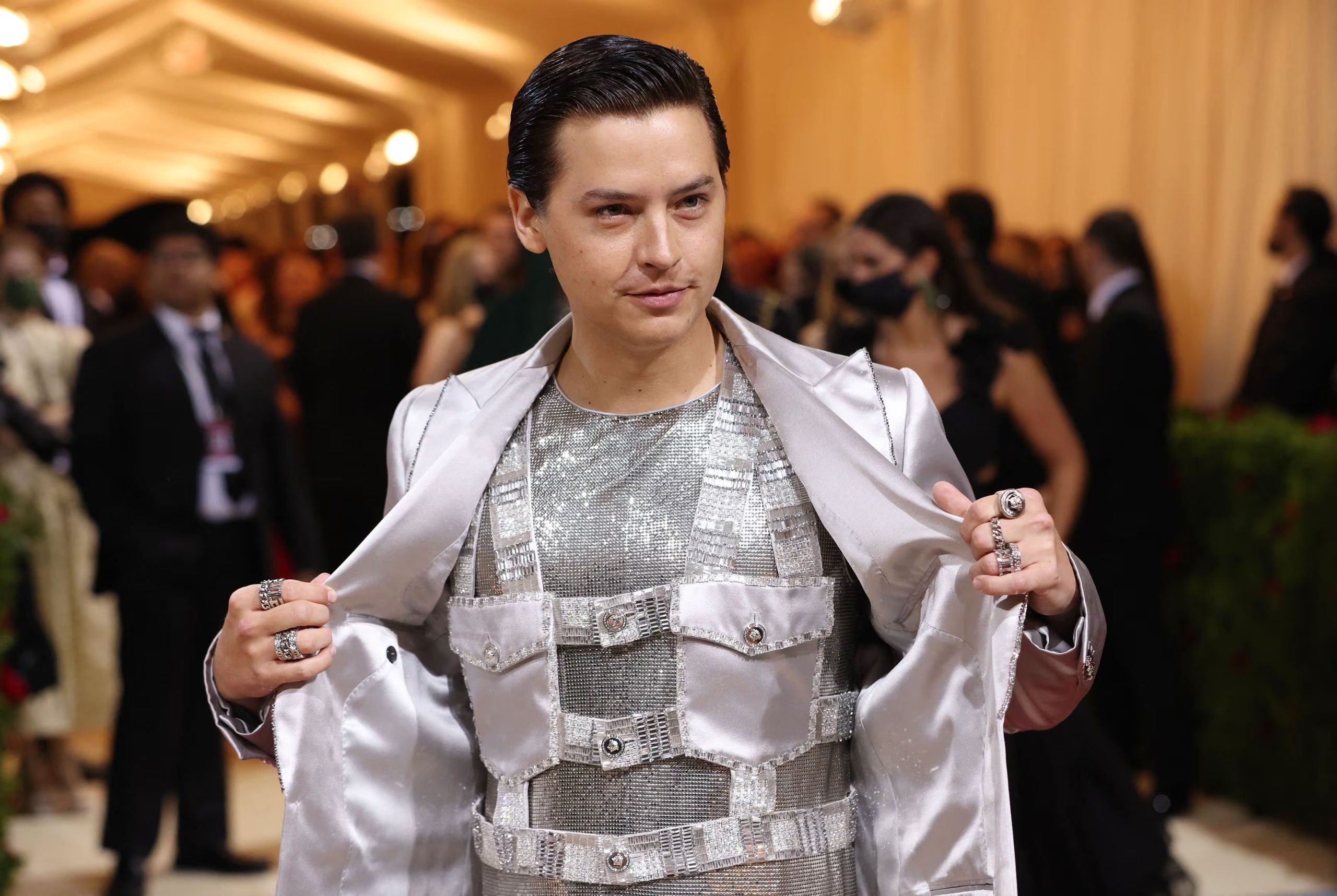 Cole Sprouse elige un chaleco de paneles metálicos y blazer satinado en tonos plateados (REUTERS/Andrew Kelly)