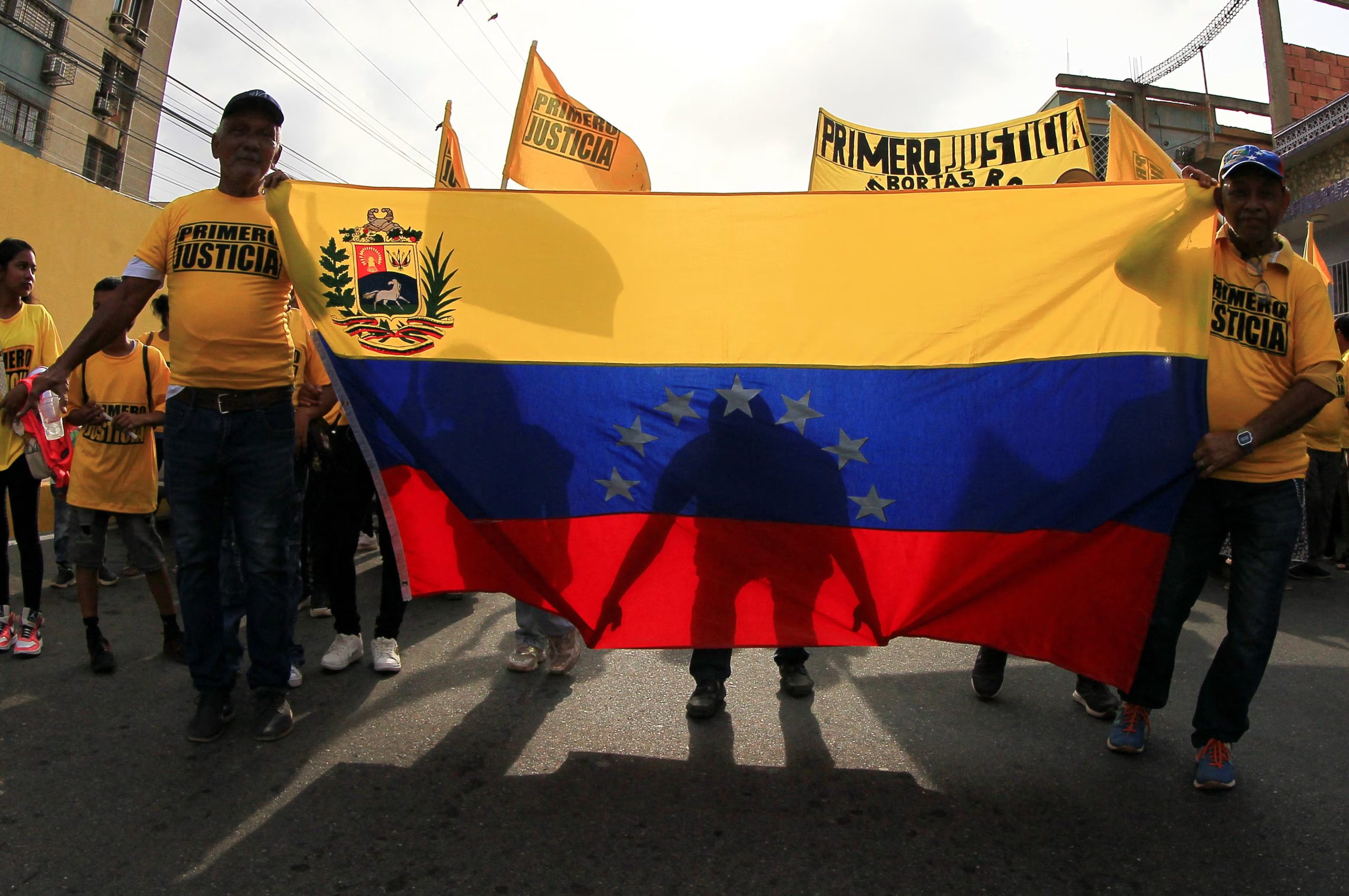 Simpatizantes del político opositor venezolano Juan Pablo Guanipa portan una bandera venezolana durante una reunión en la que Guanipa exige elecciones libres y la liberación de los presos políticos en Maracaibo, Venezuela, el 30 de mayo de 2026 (REUTERS/Issac Urrutia)